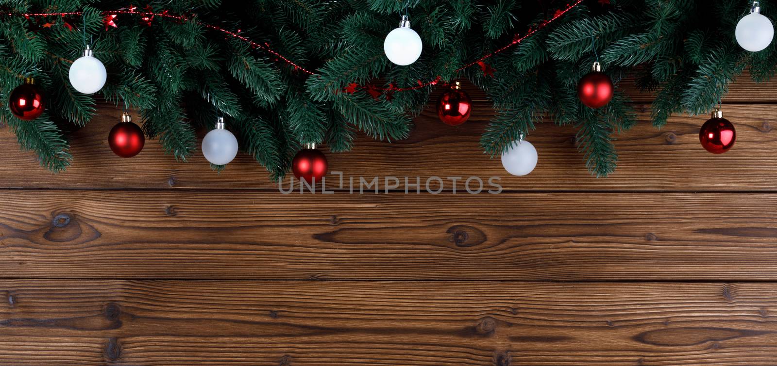Christmas tree decoration frame on wooden background , fir tree branch , red and white baubles , copy space for text