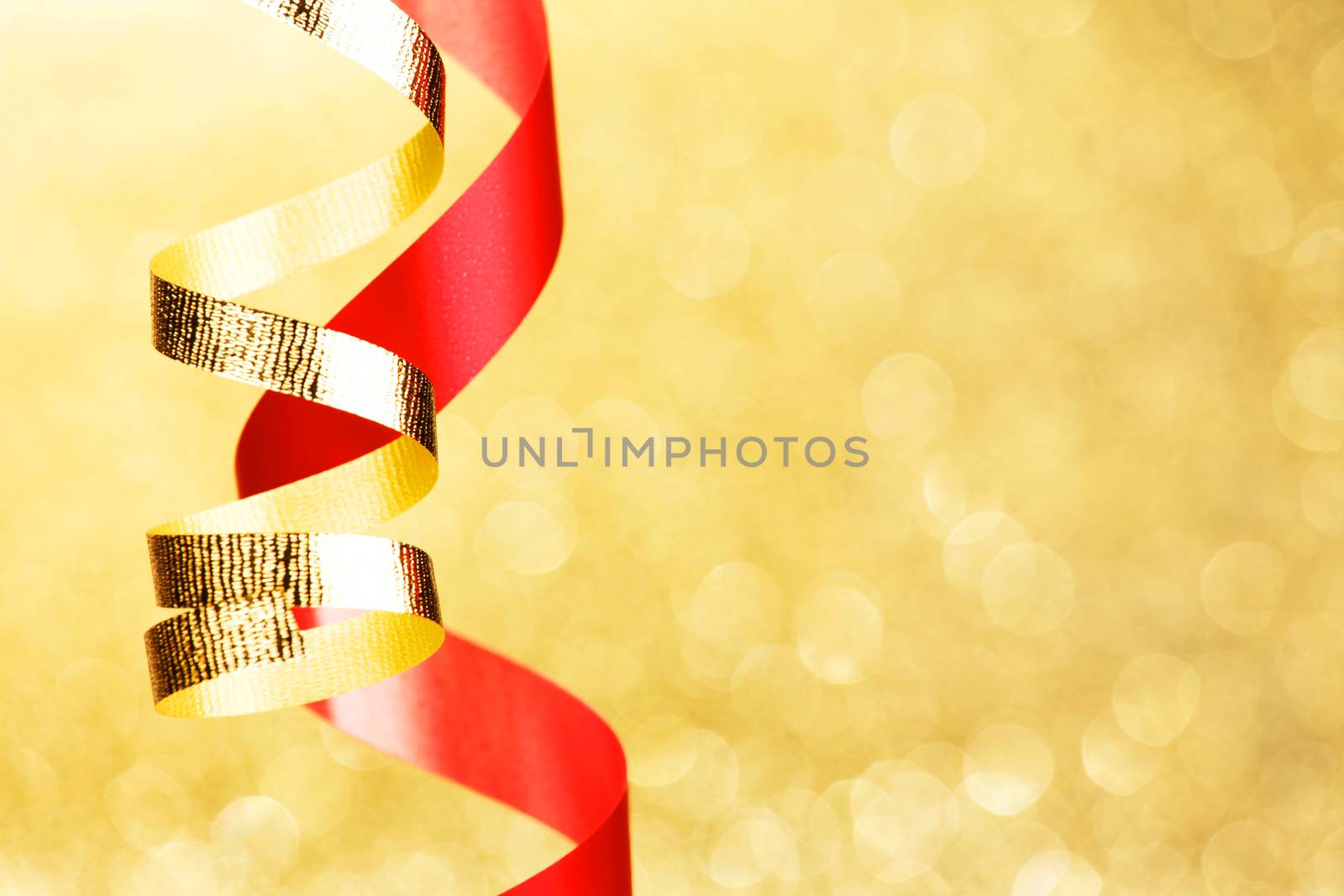 Colorful decorative curling ribbons over glitter background