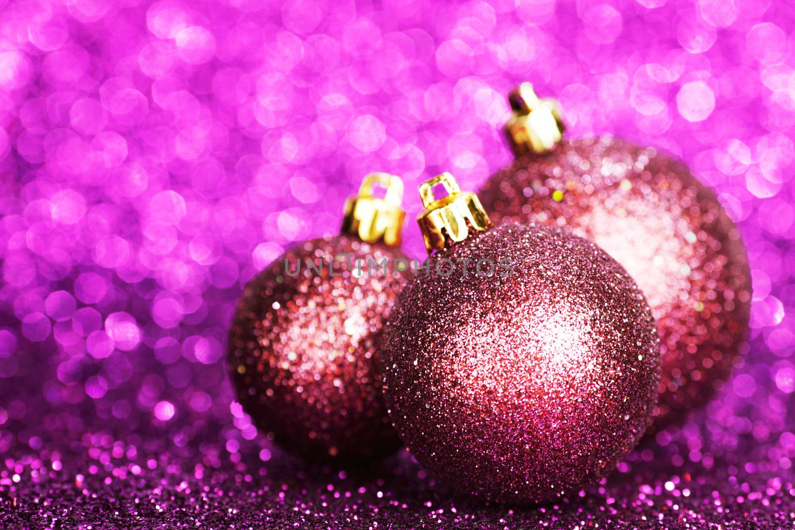 Purple christmas balls over shiny glitter background