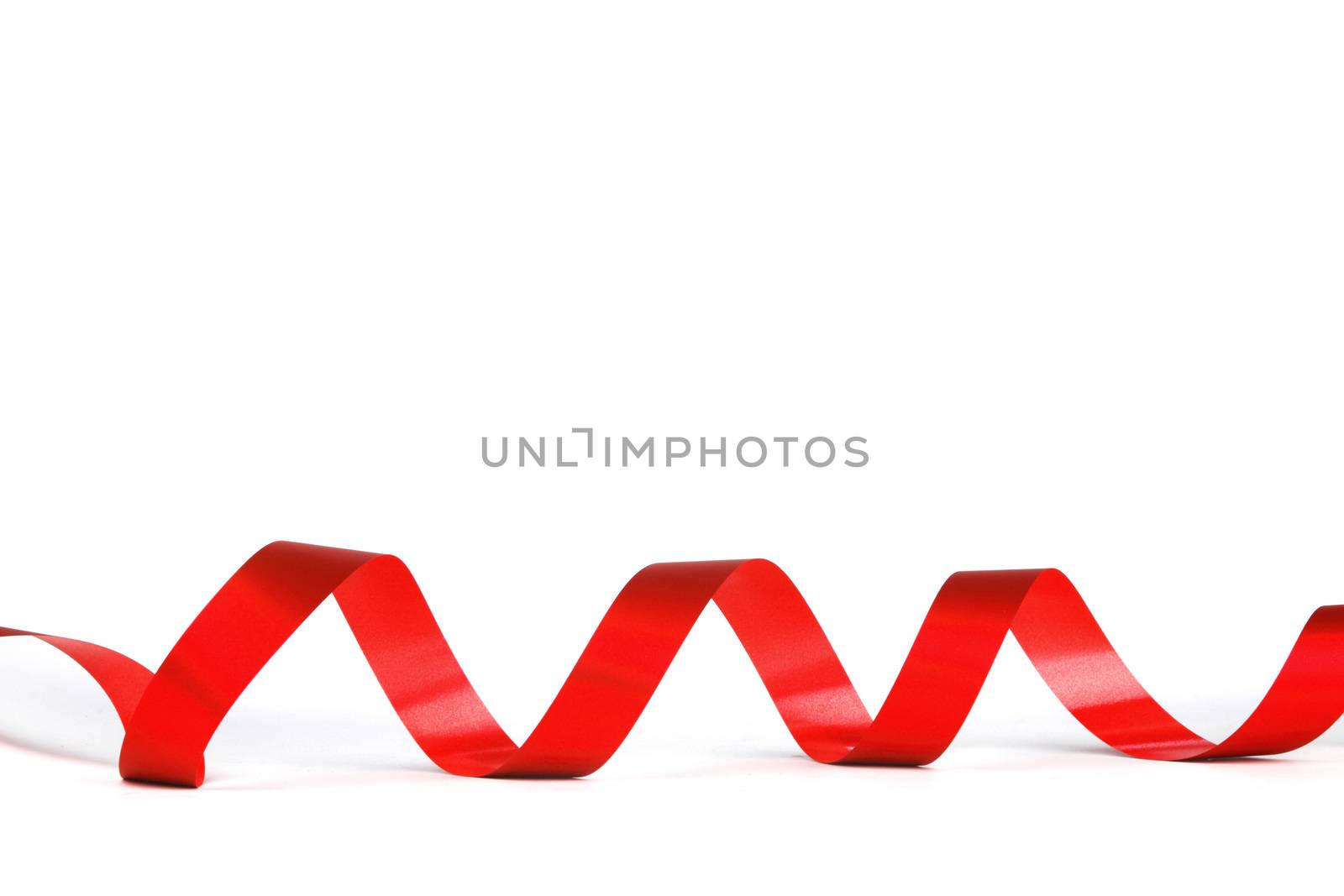Curly red gift ribbon on white background close-up