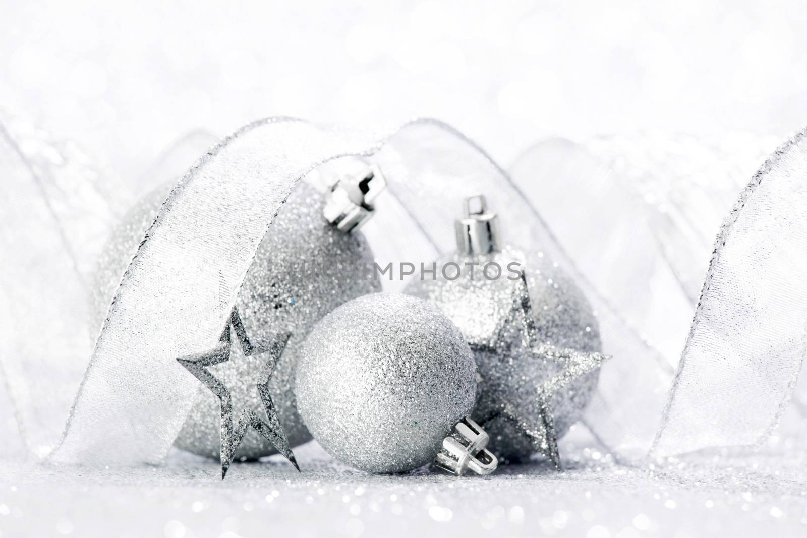 Christmas decorative balls and ribbon on silver glitter background