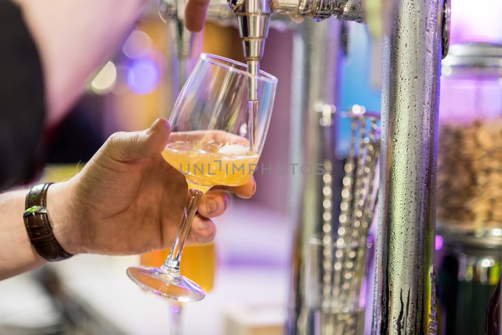 Bartender pouring lager beer in a glass. Shallow dof, selective focus. by HERRAEZ