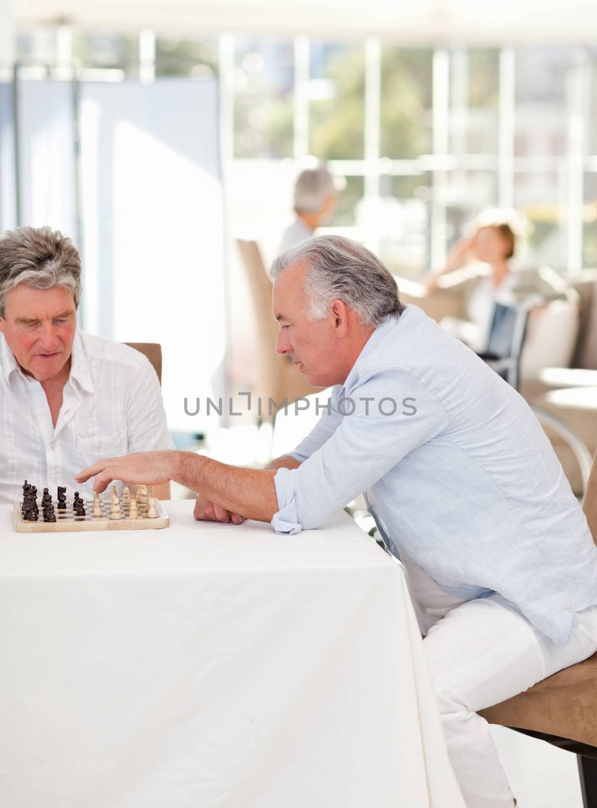 Seniors playing chess in the living room