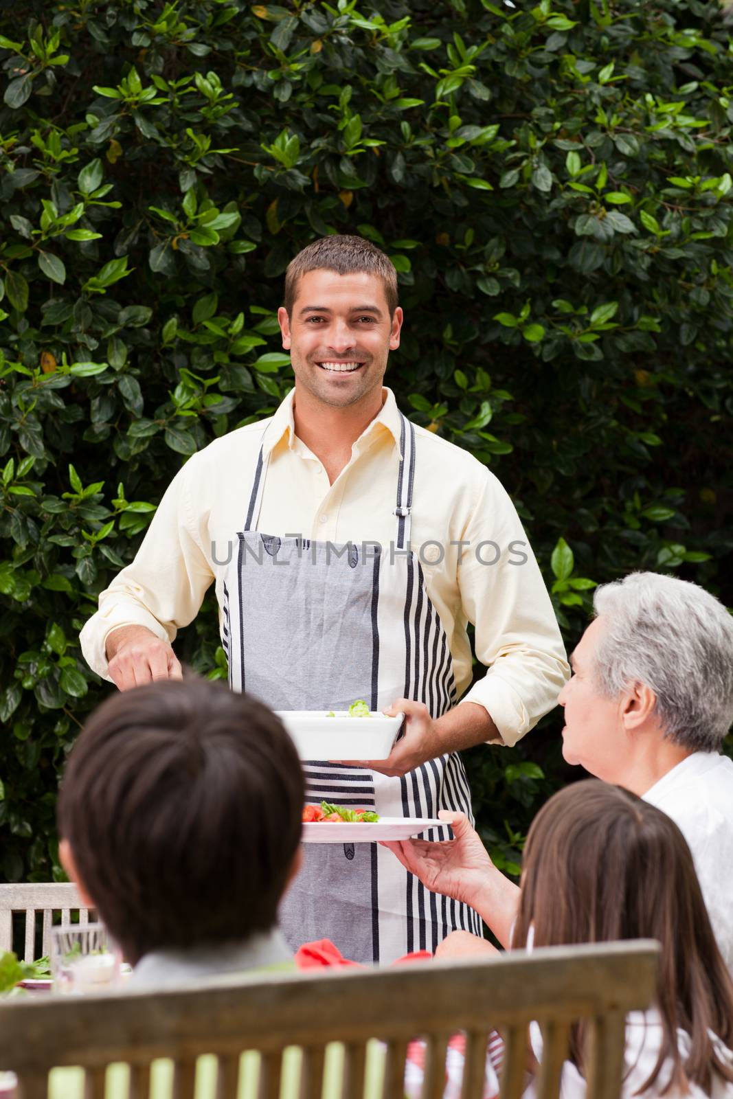 Man serving his mother at the table by Wavebreakmedia