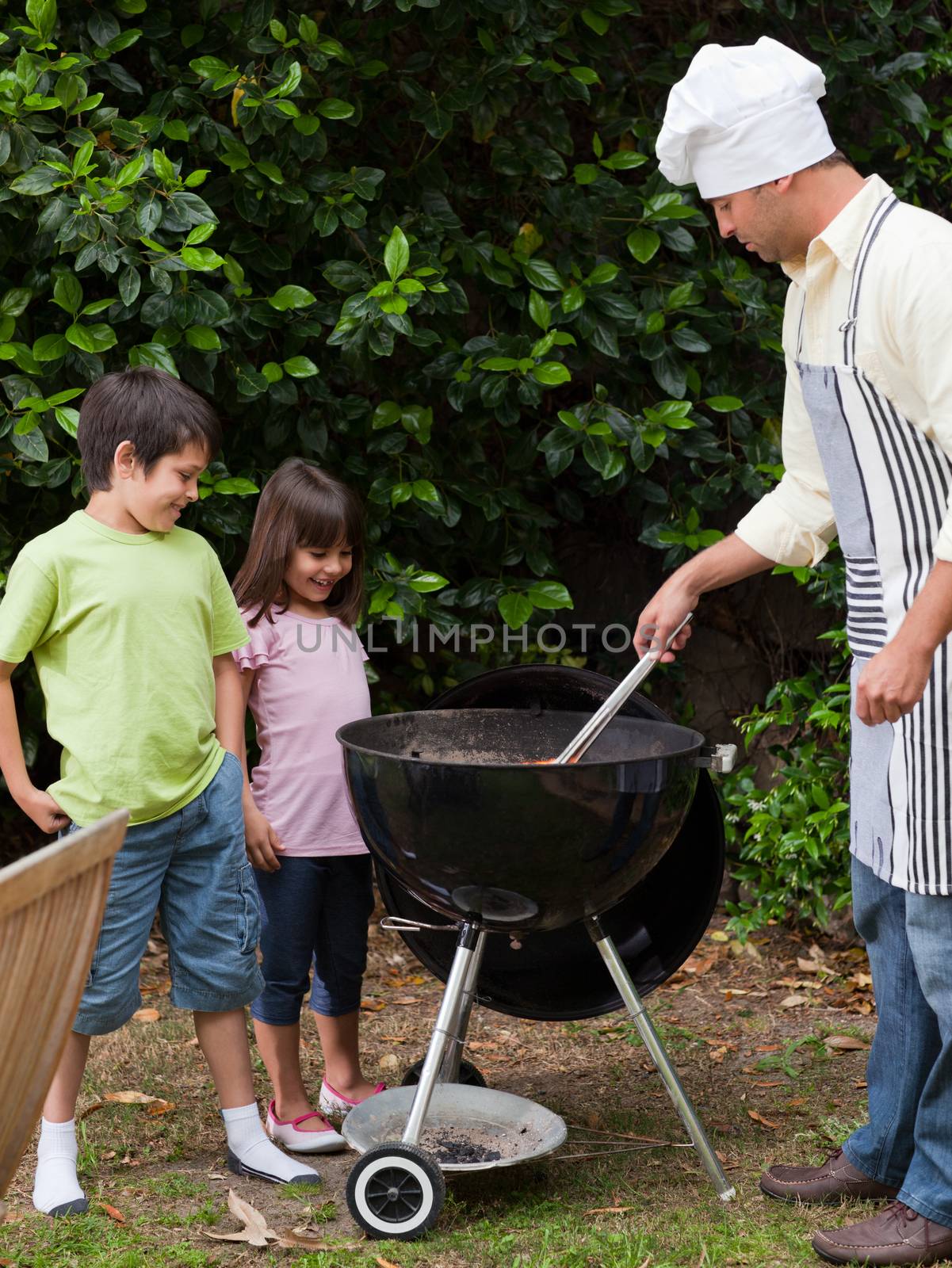 Family having a barbecue in the garden  by Wavebreakmedia