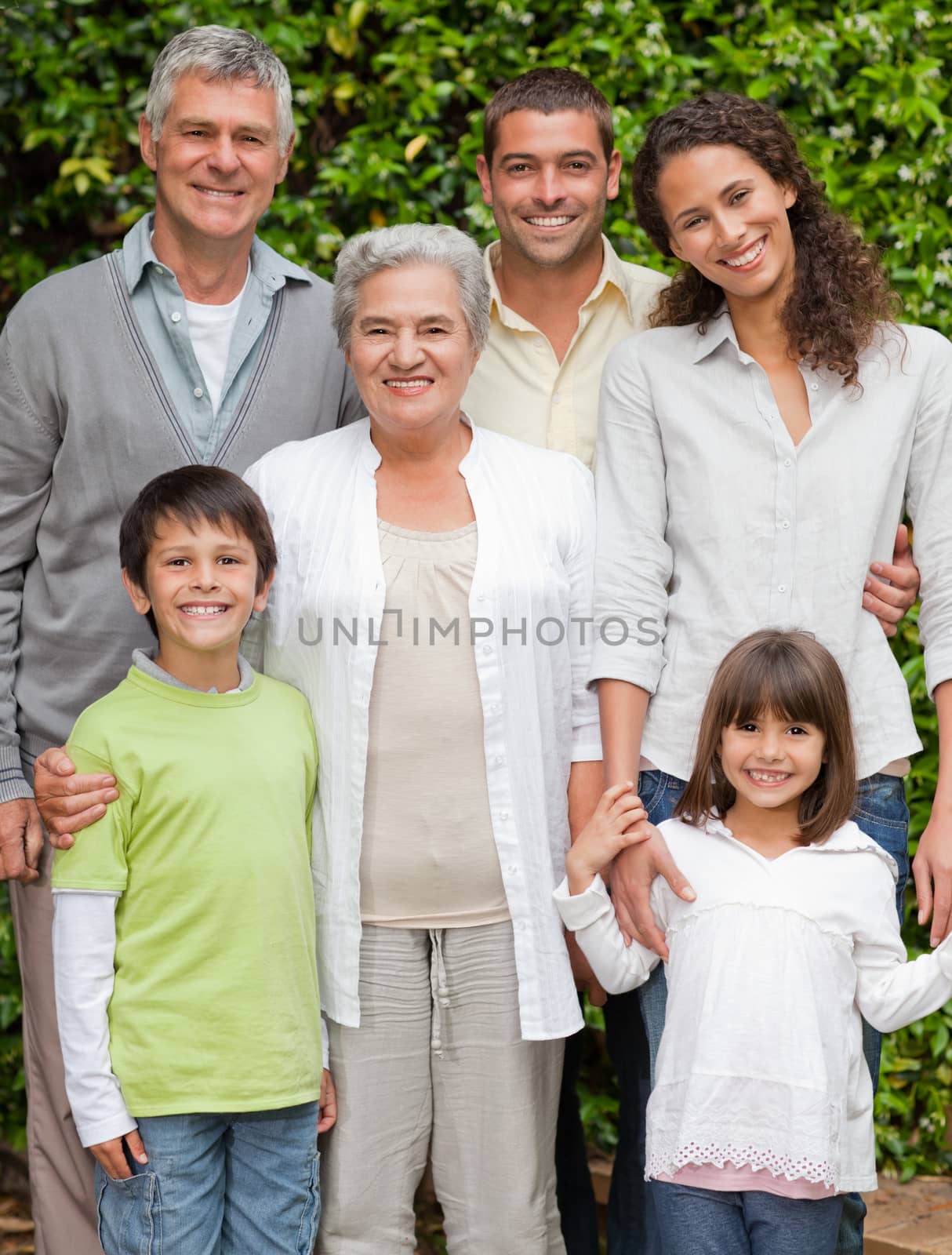 Portrait of a happy family looking at the camera in the garden by Wavebreakmedia