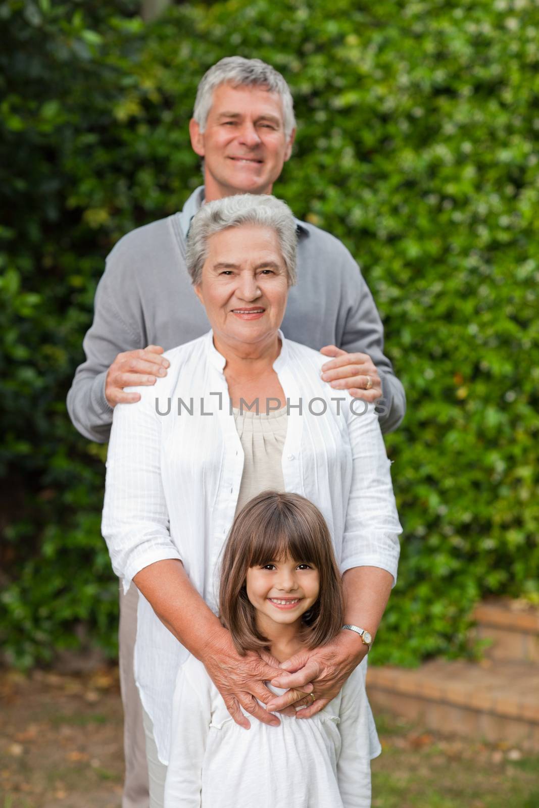Smiling family looking at the camera in the garden by Wavebreakmedia