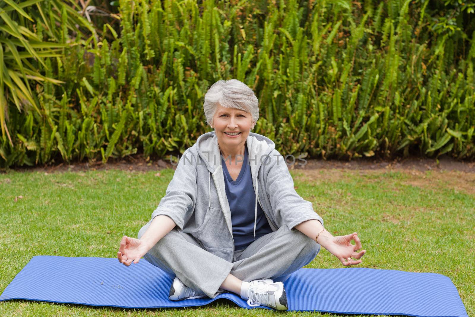 Retired woman practicing yoga in the garden by Wavebreakmedia