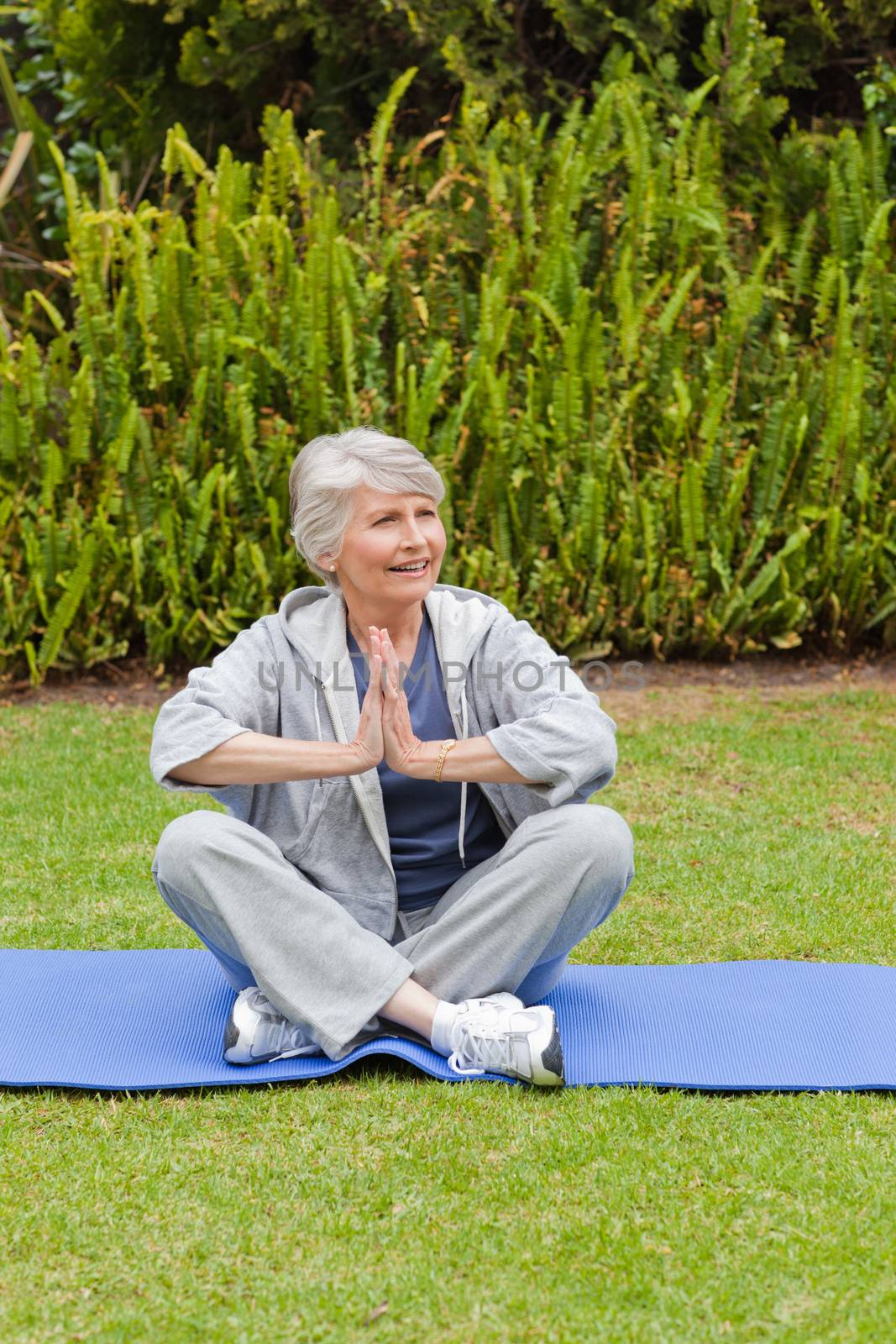 Retired woman practicing yoga in the garden by Wavebreakmedia