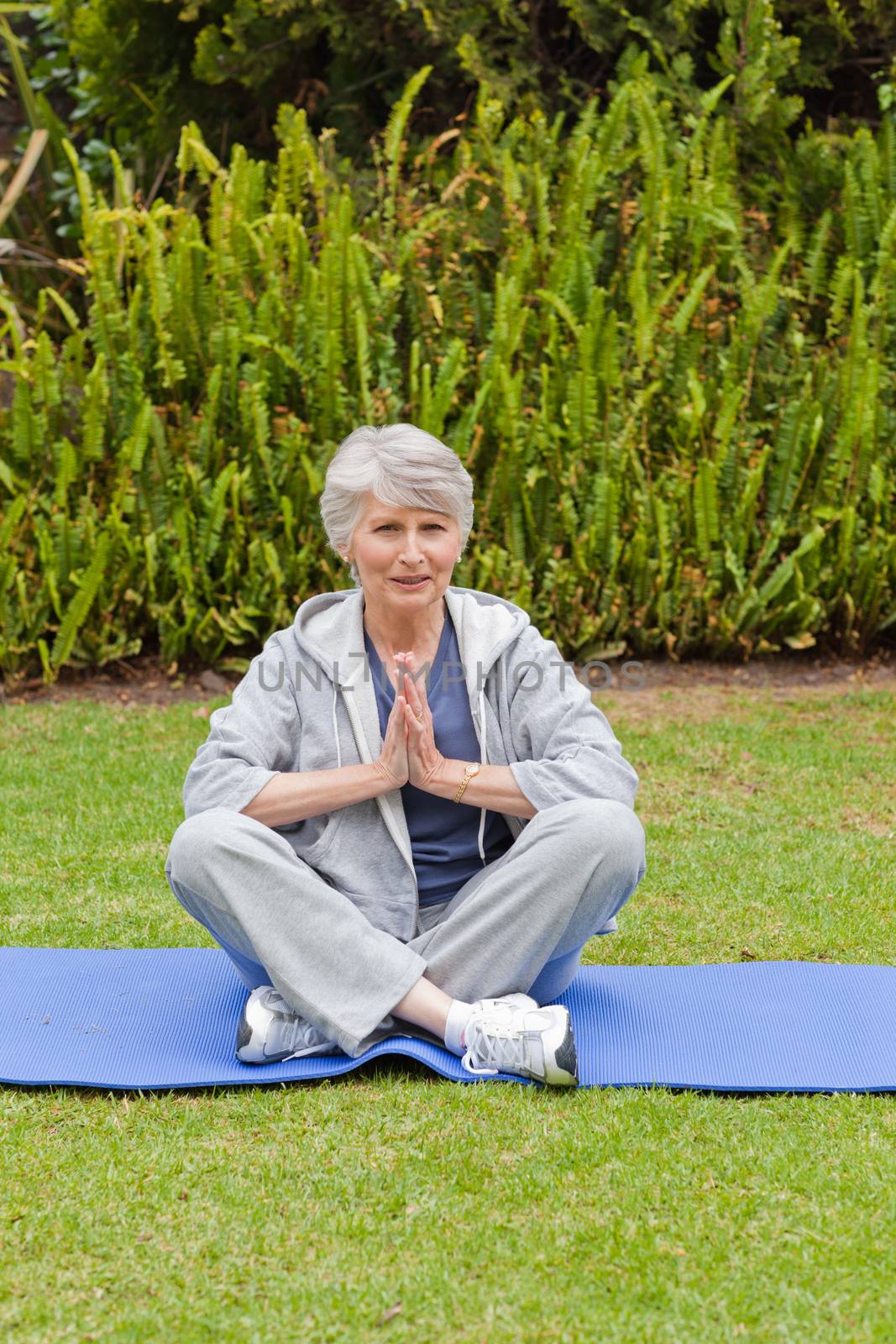 Retired woman practicing yoga in the garden by Wavebreakmedia