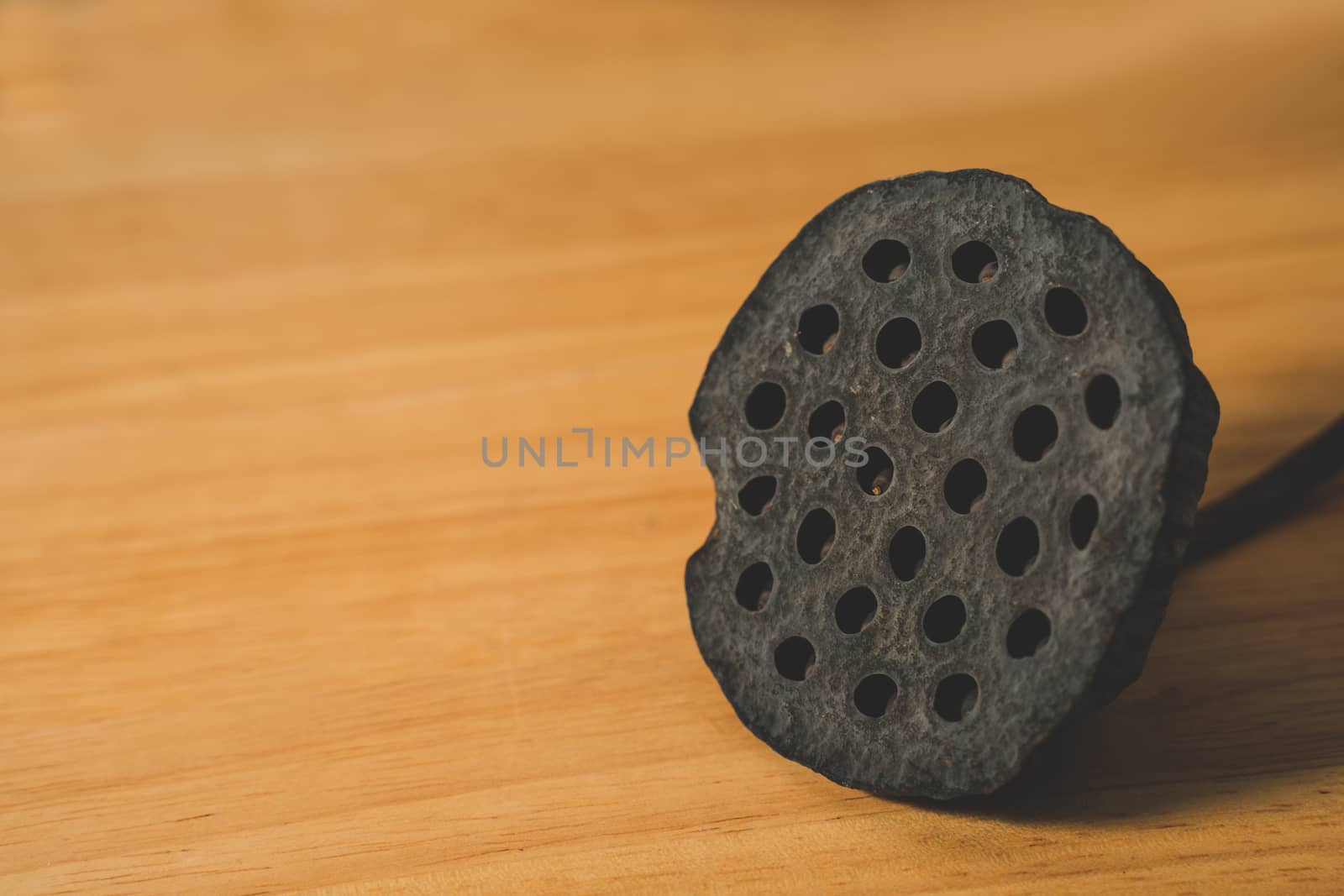 The Black dry lotus seed on wooden table background