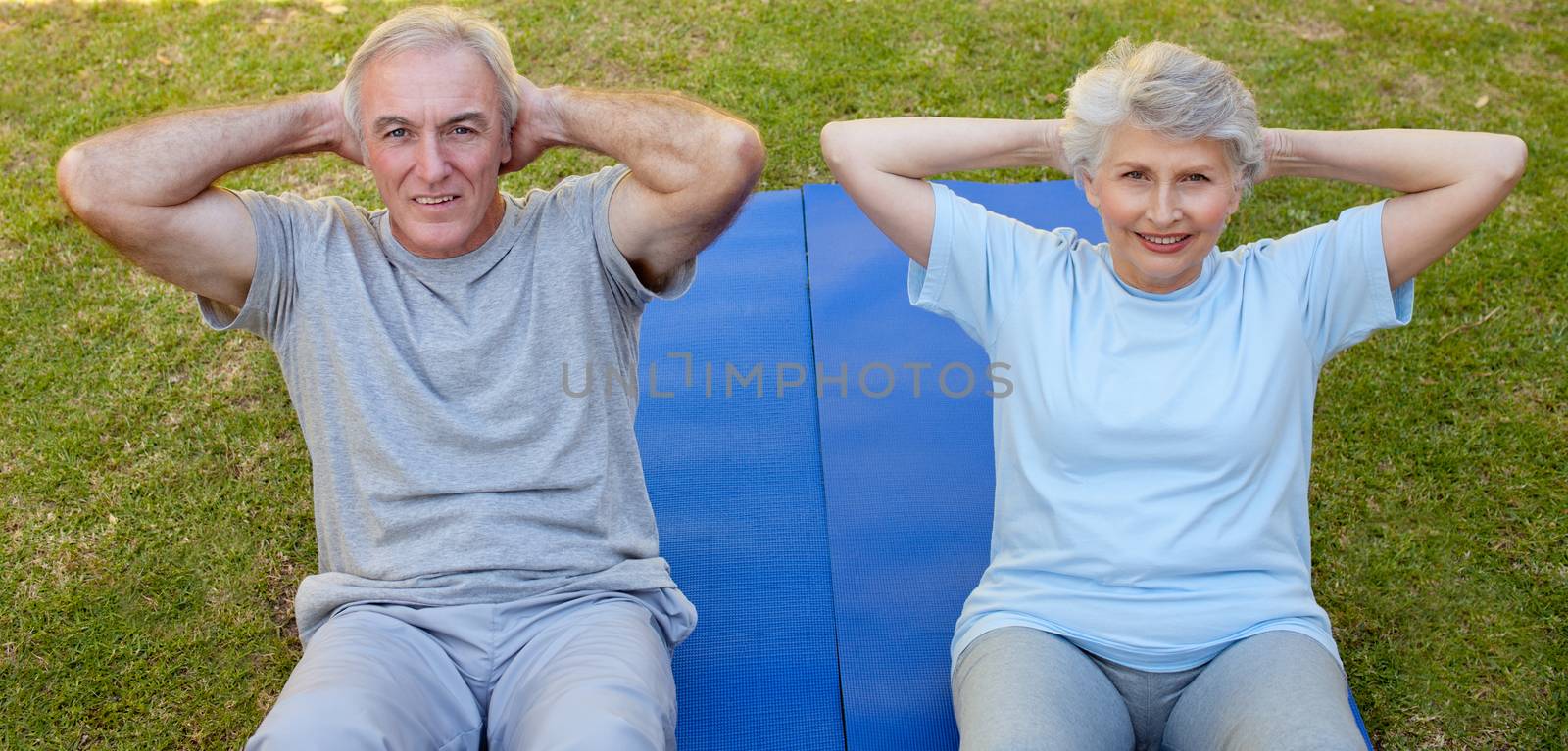 Retired couple doing their streches in the garden by Wavebreakmedia