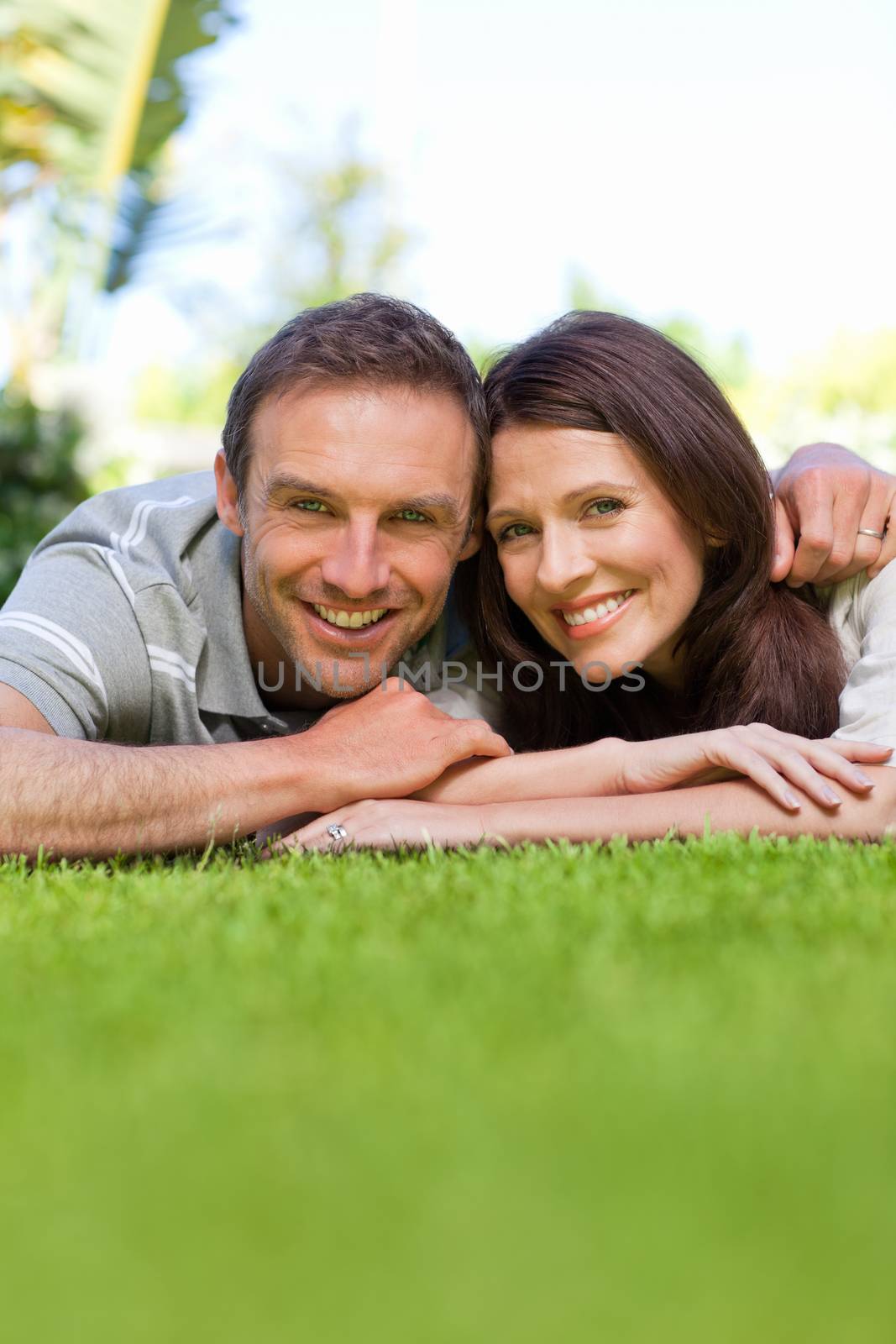 Couple lying down in the garden by Wavebreakmedia