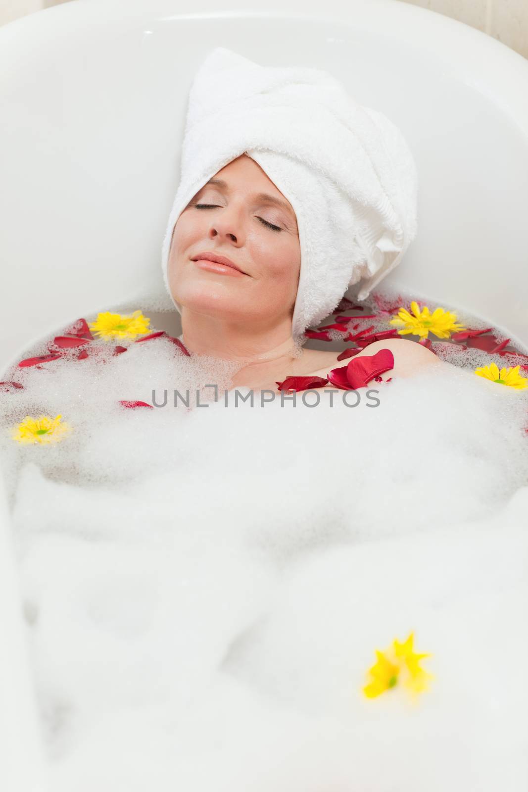 Relaxed woman taking a relaxing bath with a towel on her head  by Wavebreakmedia