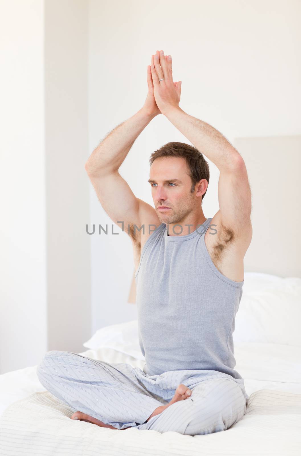 Man practicing yoga on his bed