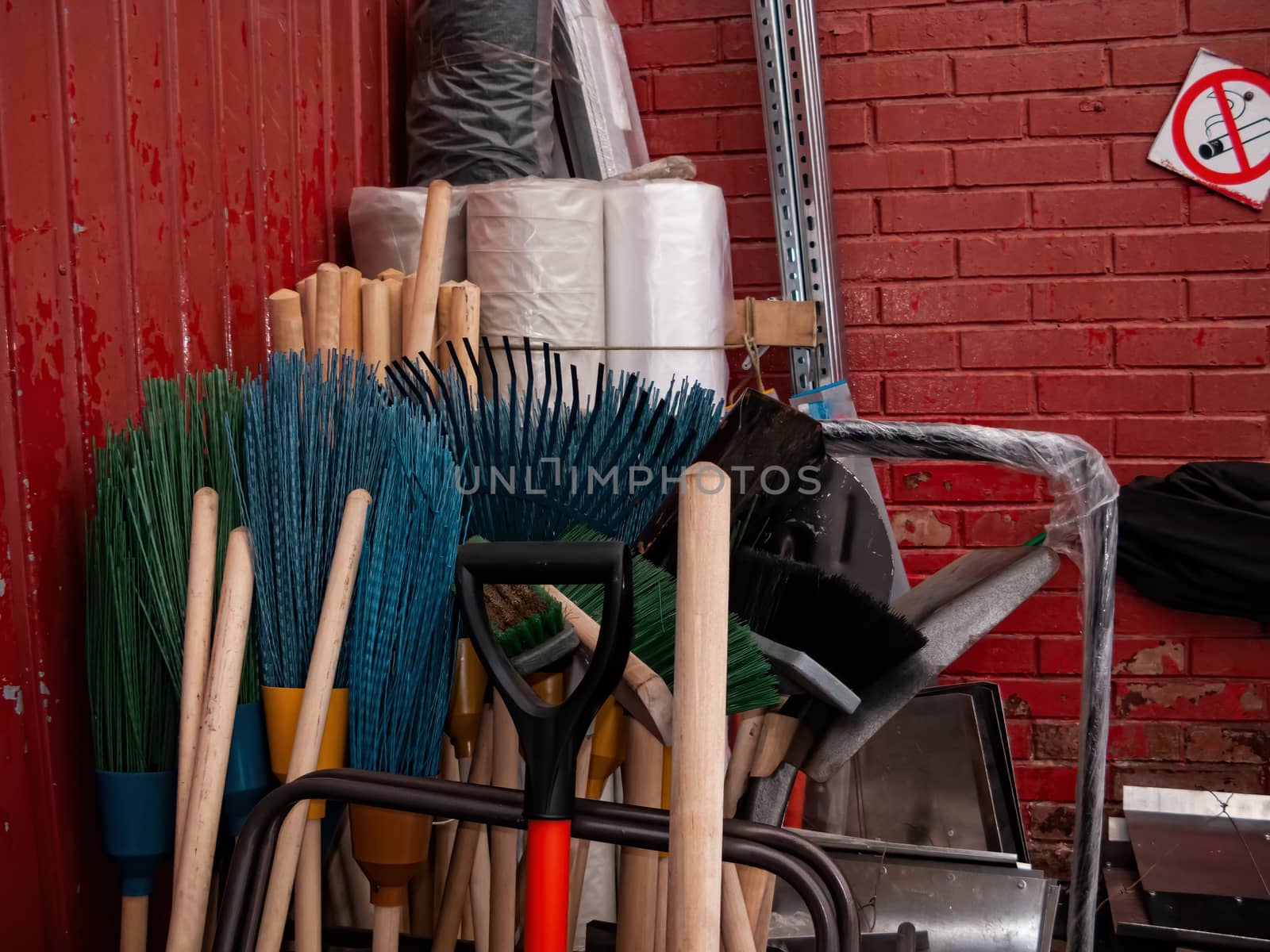 Many different tools for winter snow removal. Shovels of different shapes and brooms are in the corner. Household tool.