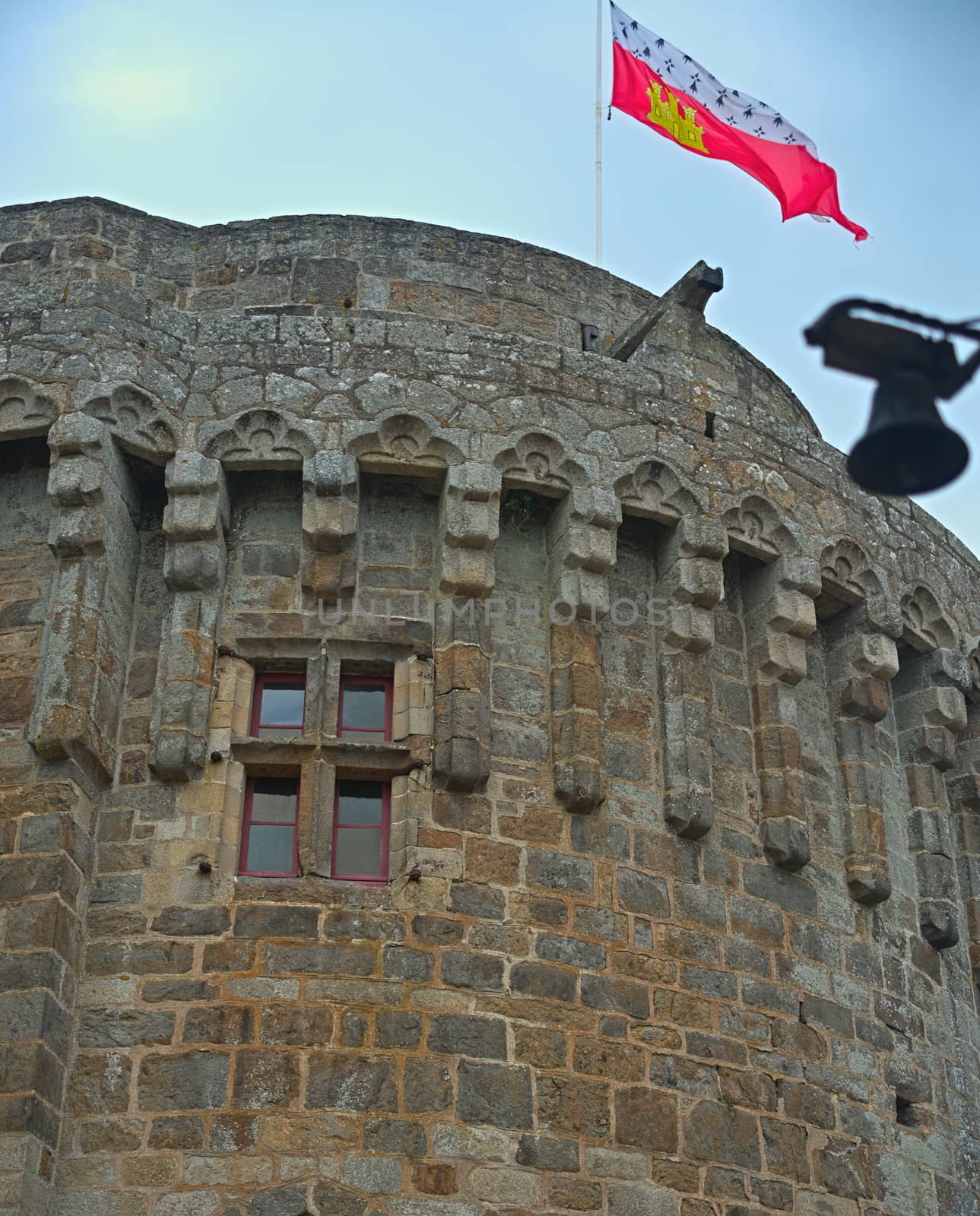 Big central stone tower with flag on top at Dinan fortress, France