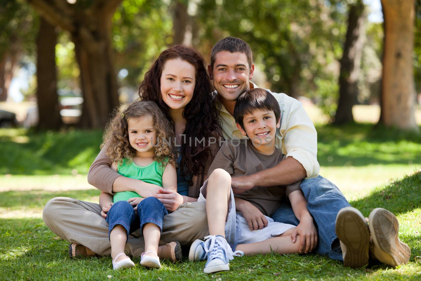 Happy family sitting in the garden by Wavebreakmedia
