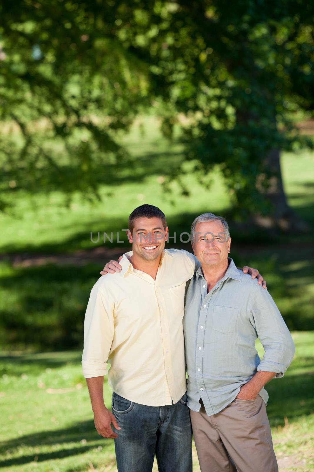 Father and his son looking at the camera in the park