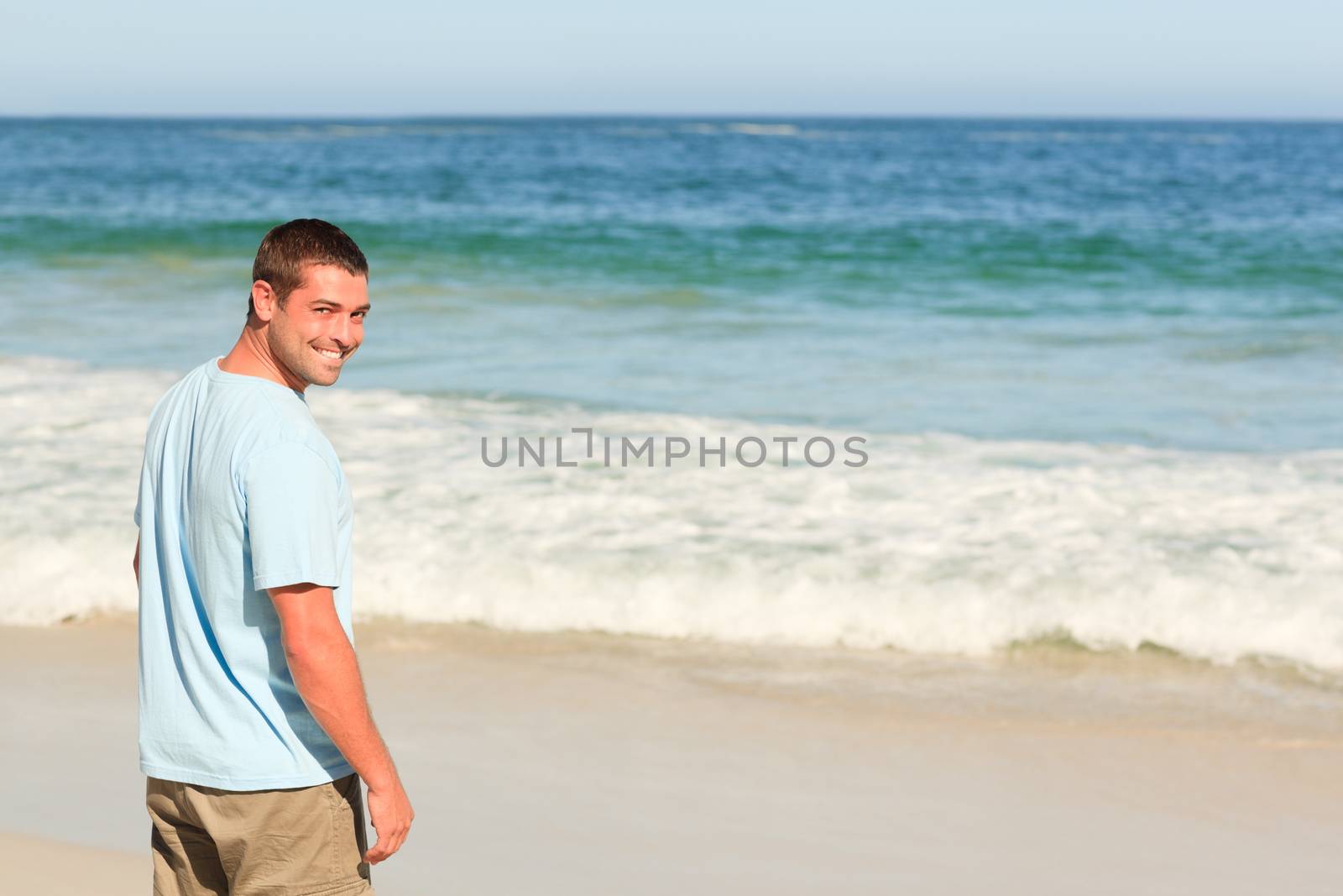 Handsome man walking on the beach by Wavebreakmedia