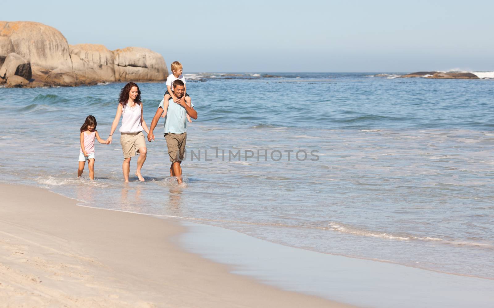 Joyful family at the beach by Wavebreakmedia