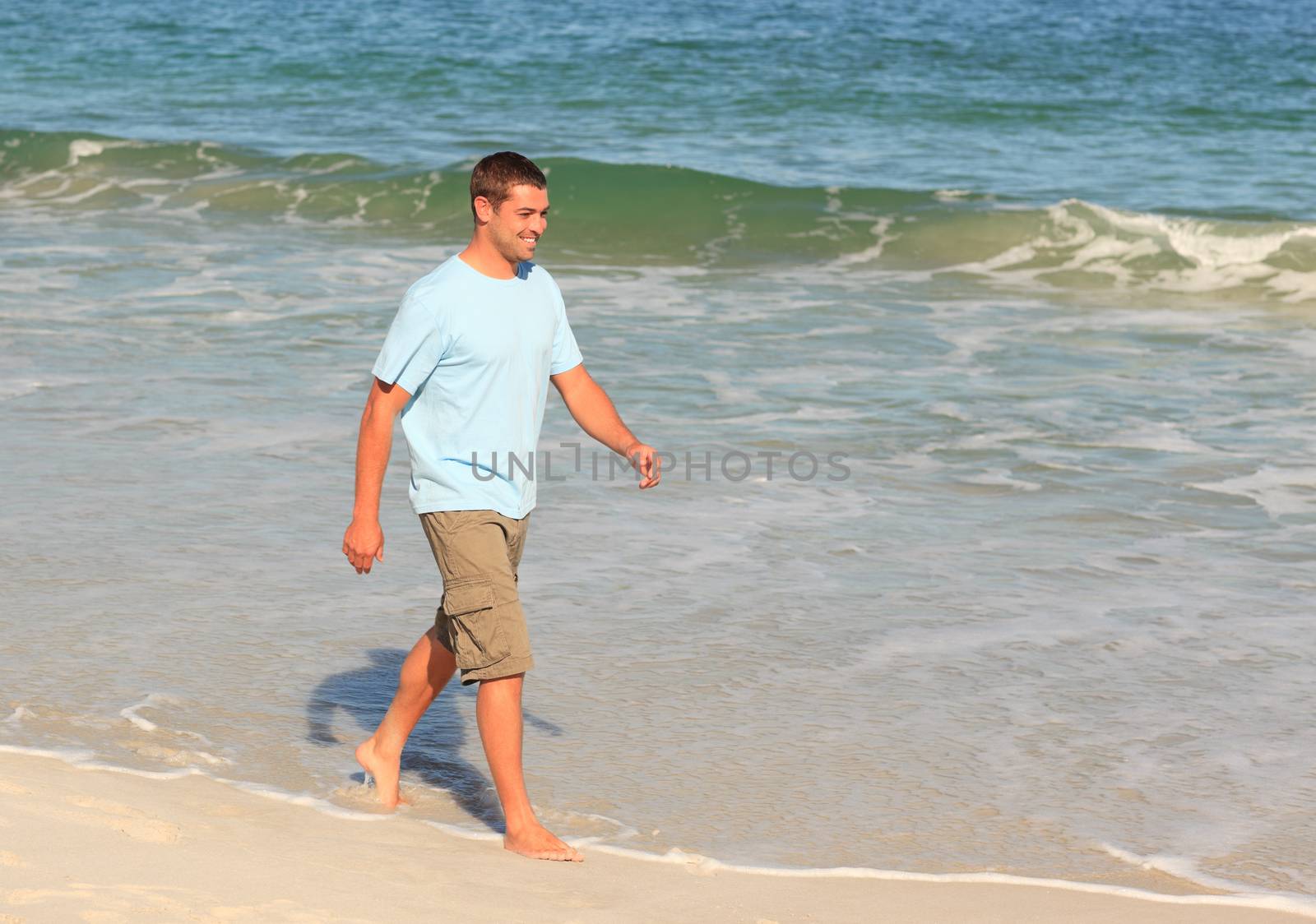 Handsome man walking on the beach