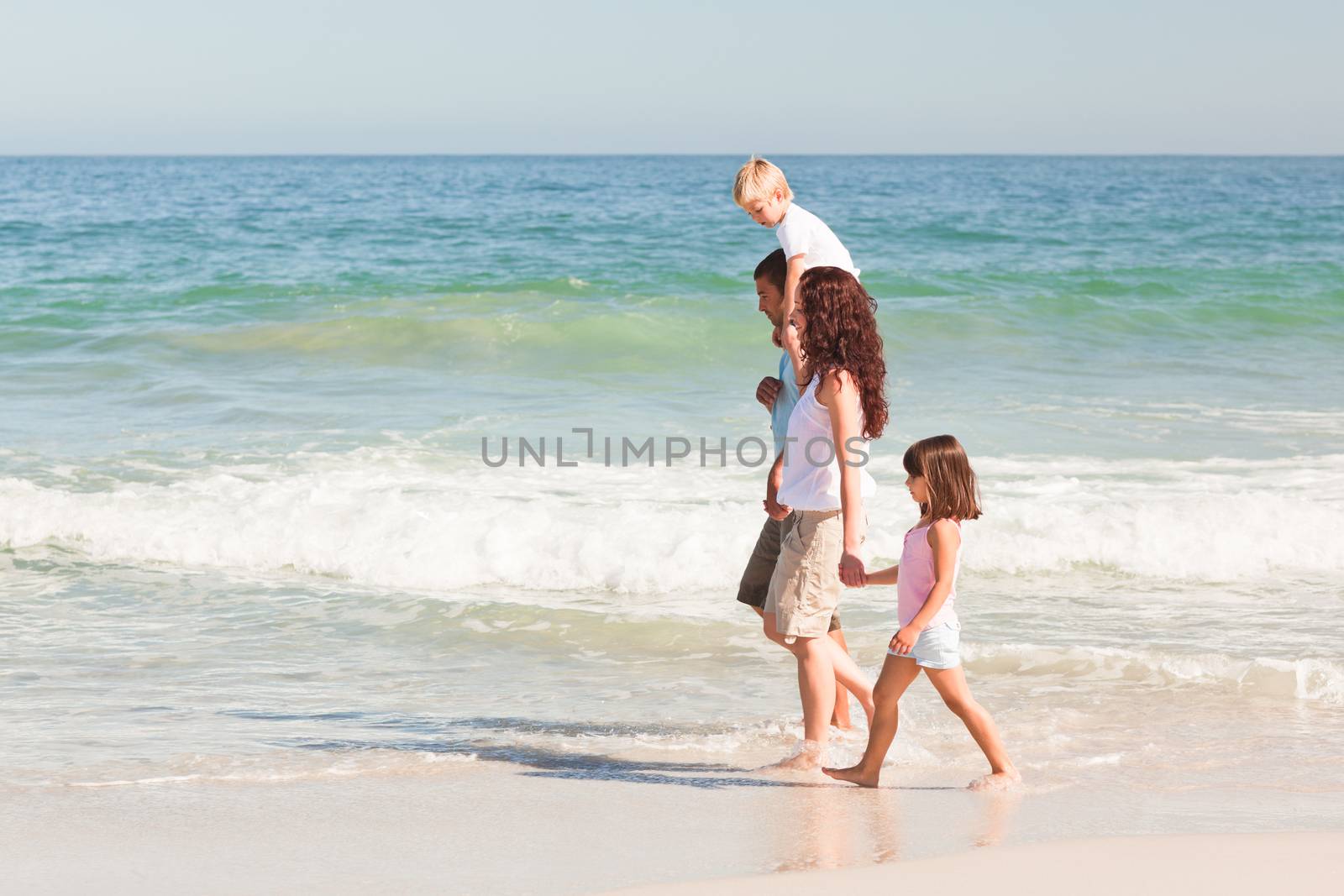 Joyful family at the beach by Wavebreakmedia