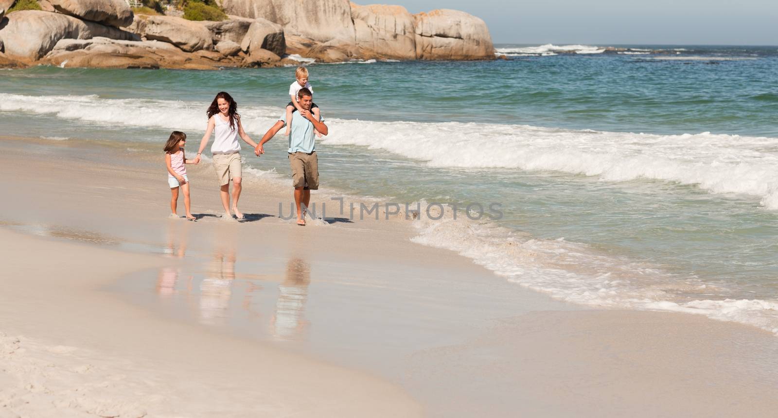 Joyful family at the beach by Wavebreakmedia