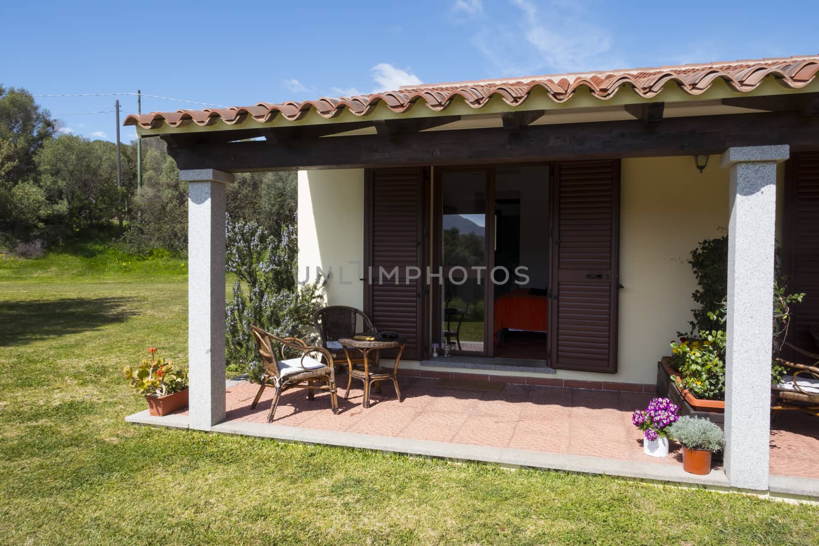 a seat on a terrace of a cottage on the Italian island of Sardinia in summer with blue sky