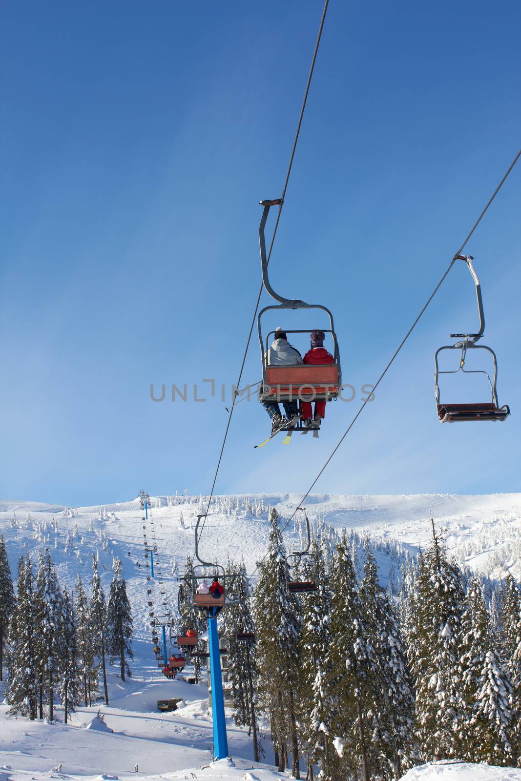 Cableway in the mountains with skiers 