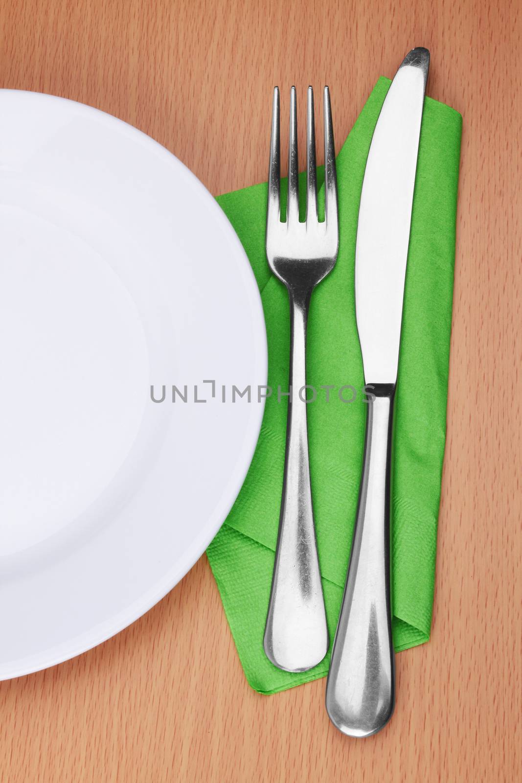 Fork and knife in a green cloth on white