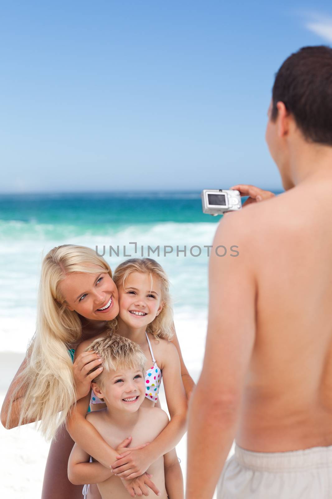 Man taking a photo of his family by Wavebreakmedia