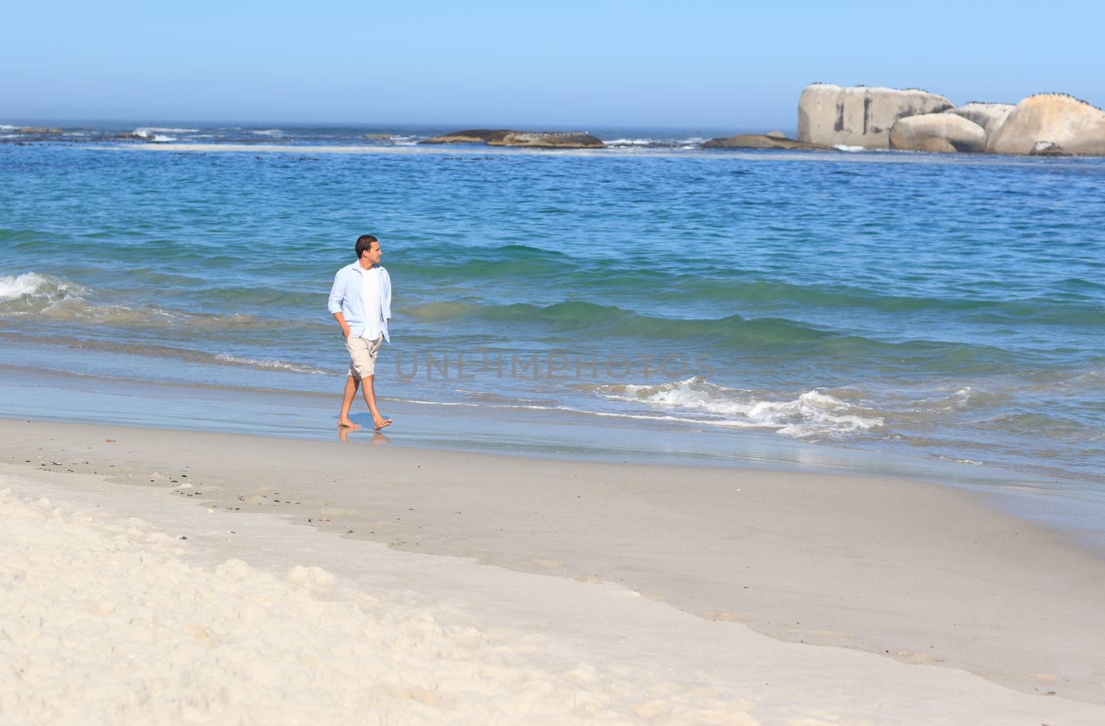 Man walking on the beach by Wavebreakmedia