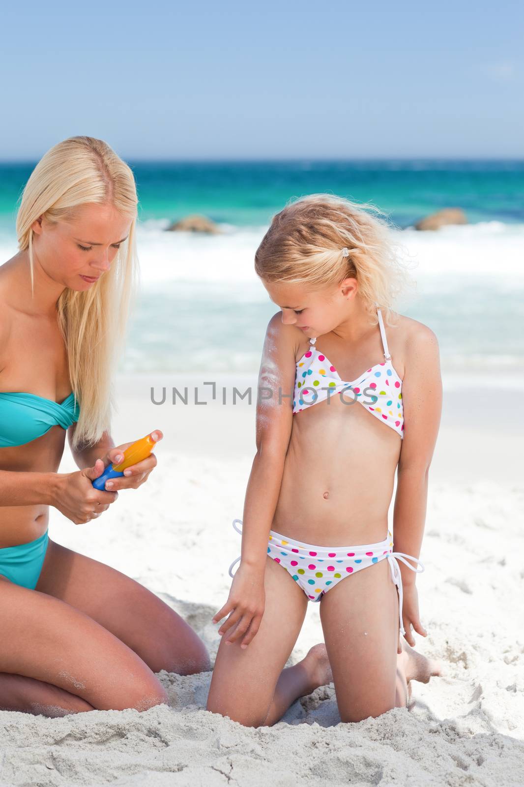 Mother applying sun cream on her daughter by Wavebreakmedia