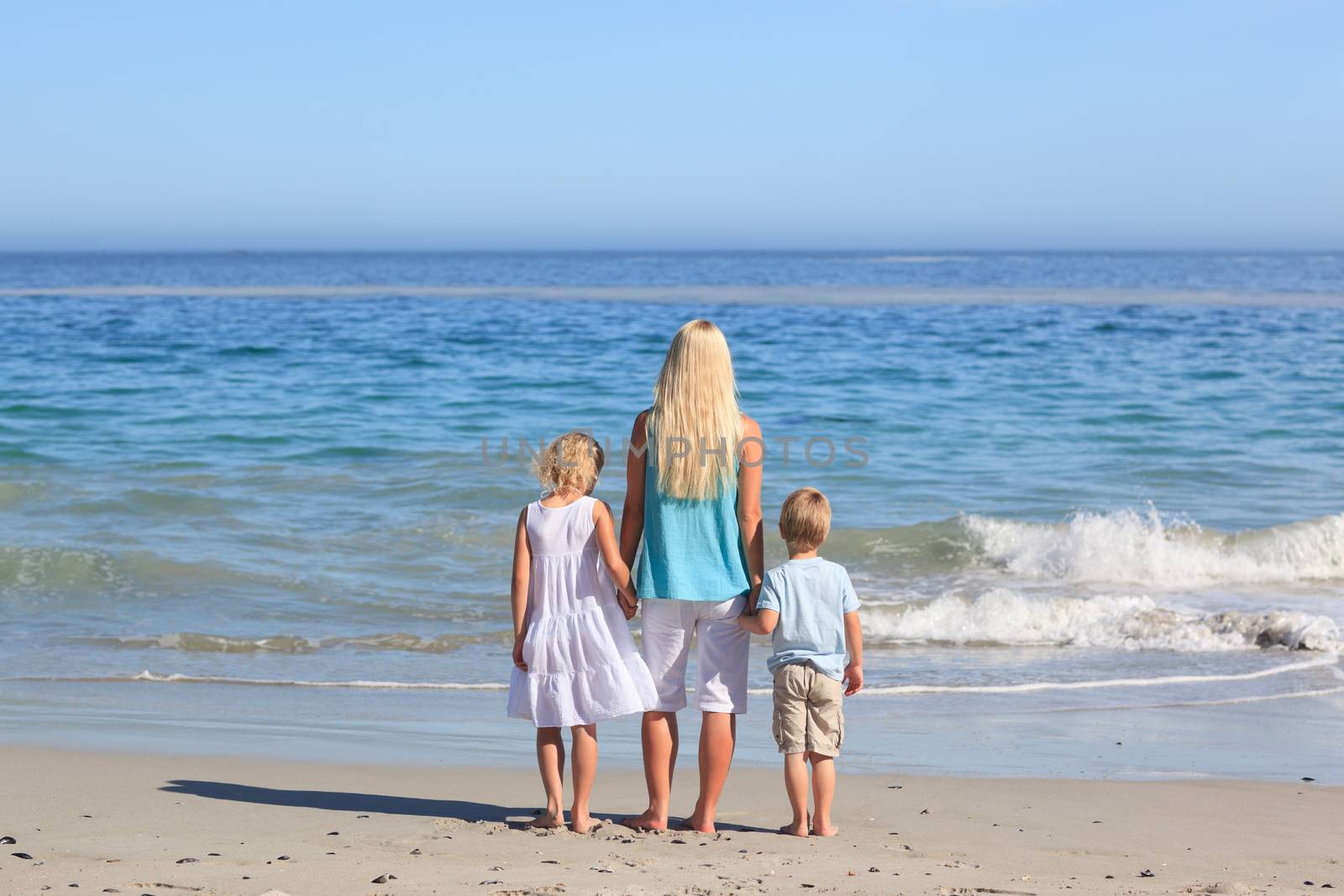Joyful family walking on the beach by Wavebreakmedia