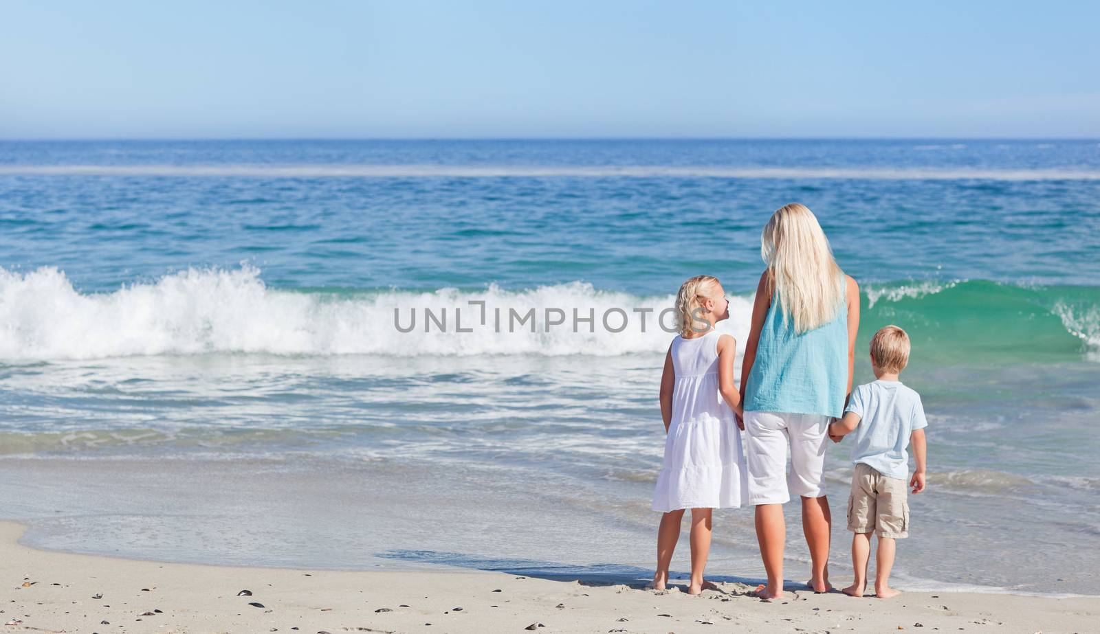 Joyful family walking on the beach