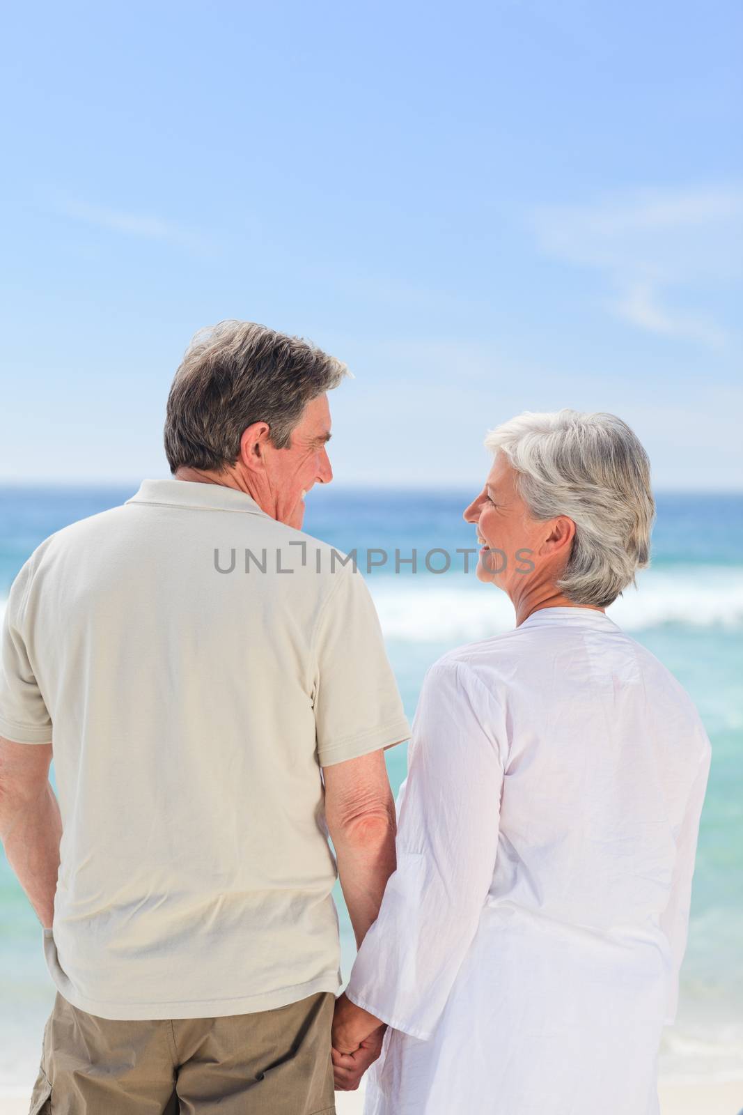 Happy couple on the beach by Wavebreakmedia