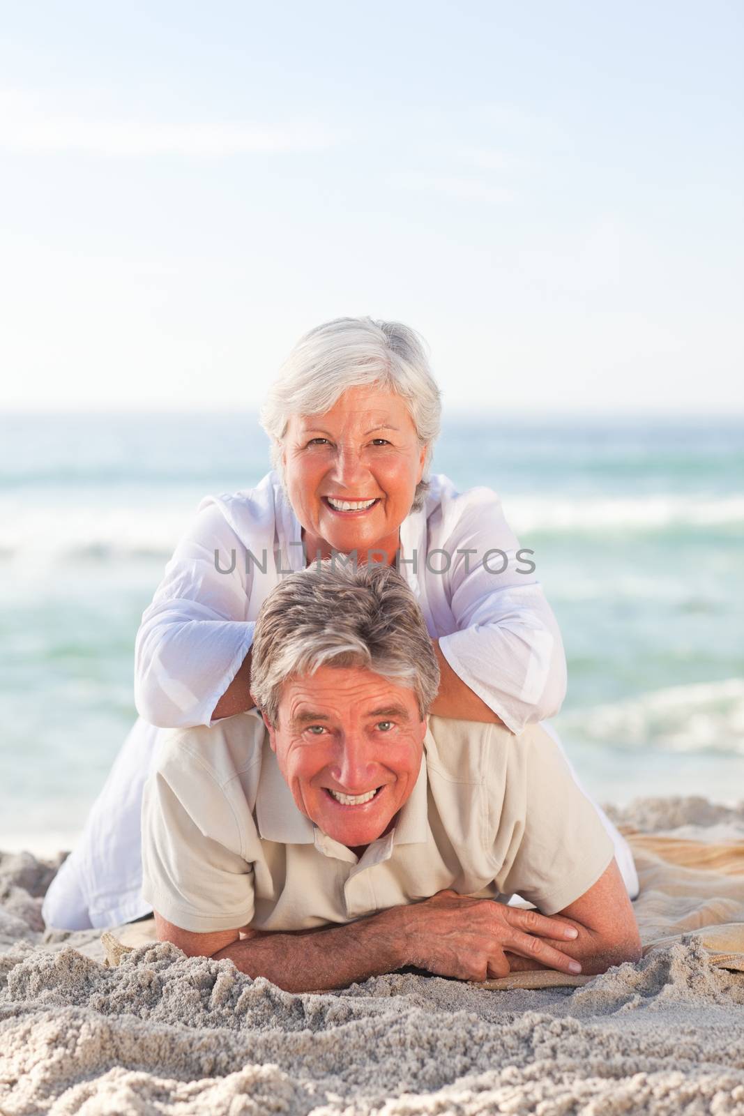Elderly couple lying down on the beach by Wavebreakmedia