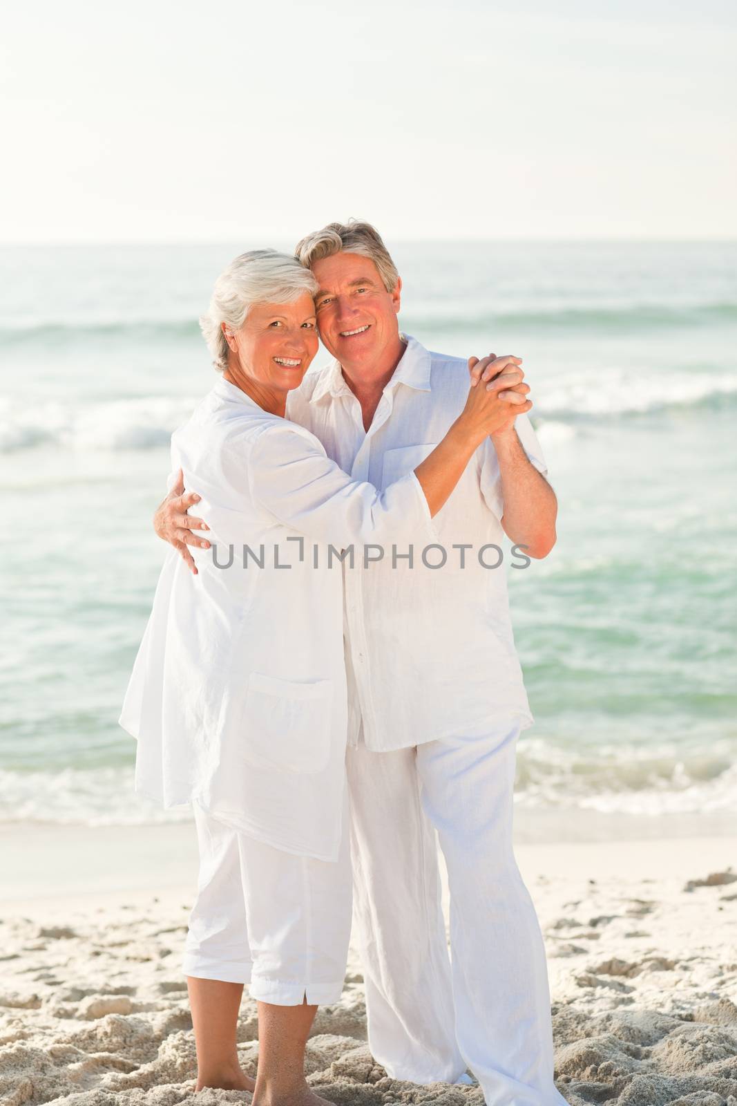 Elderly couple dancing on the beach by Wavebreakmedia