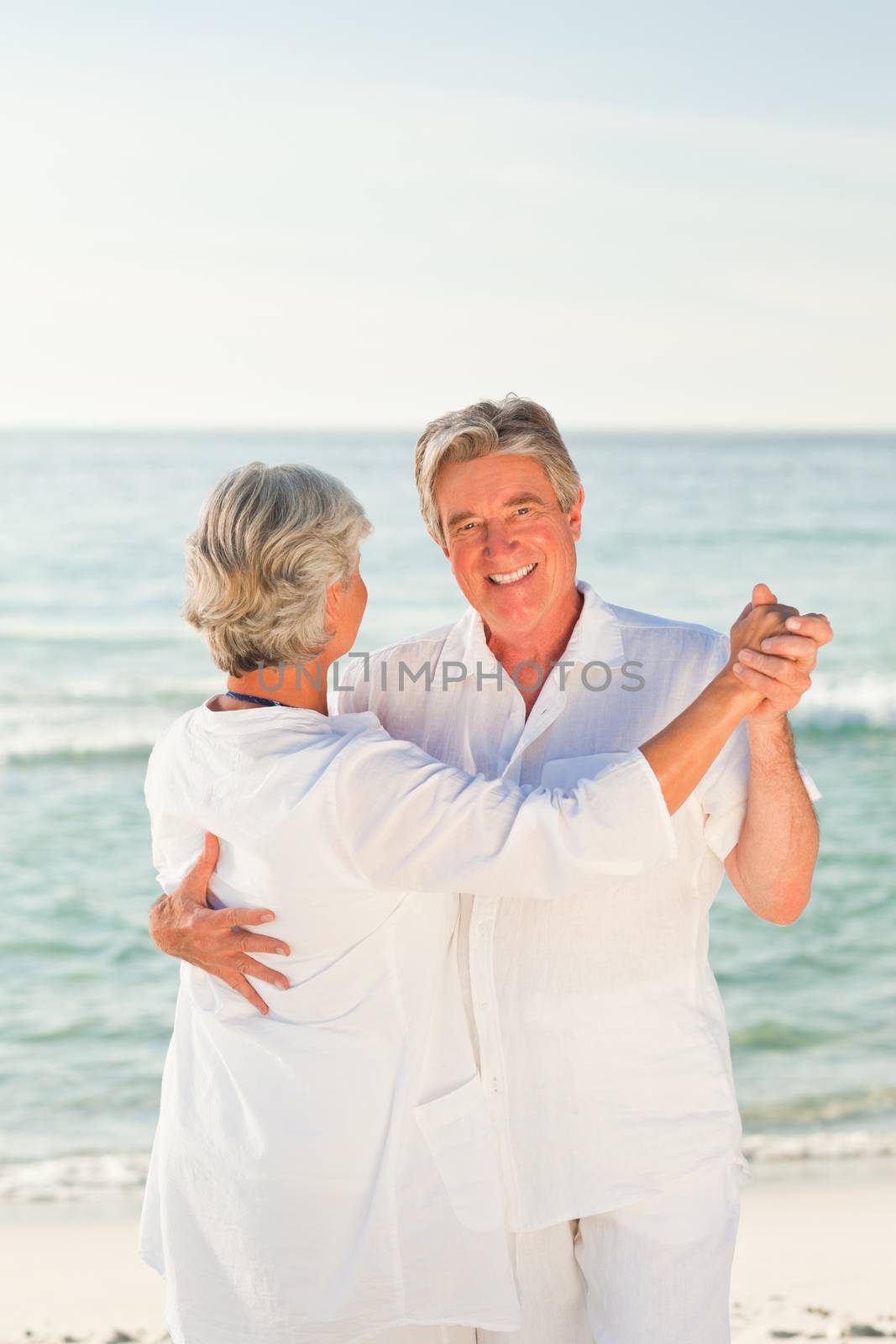 Mature couple dancing on the beach by Wavebreakmedia