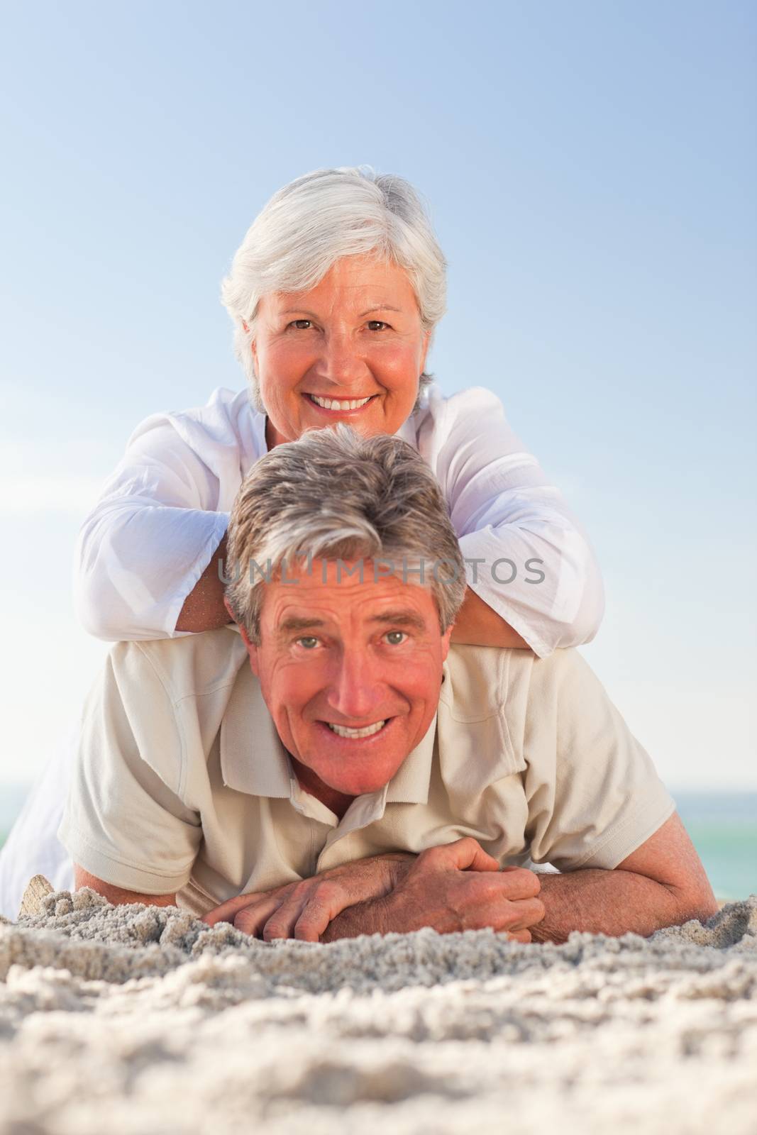 Senior couple lying down on the beach by Wavebreakmedia