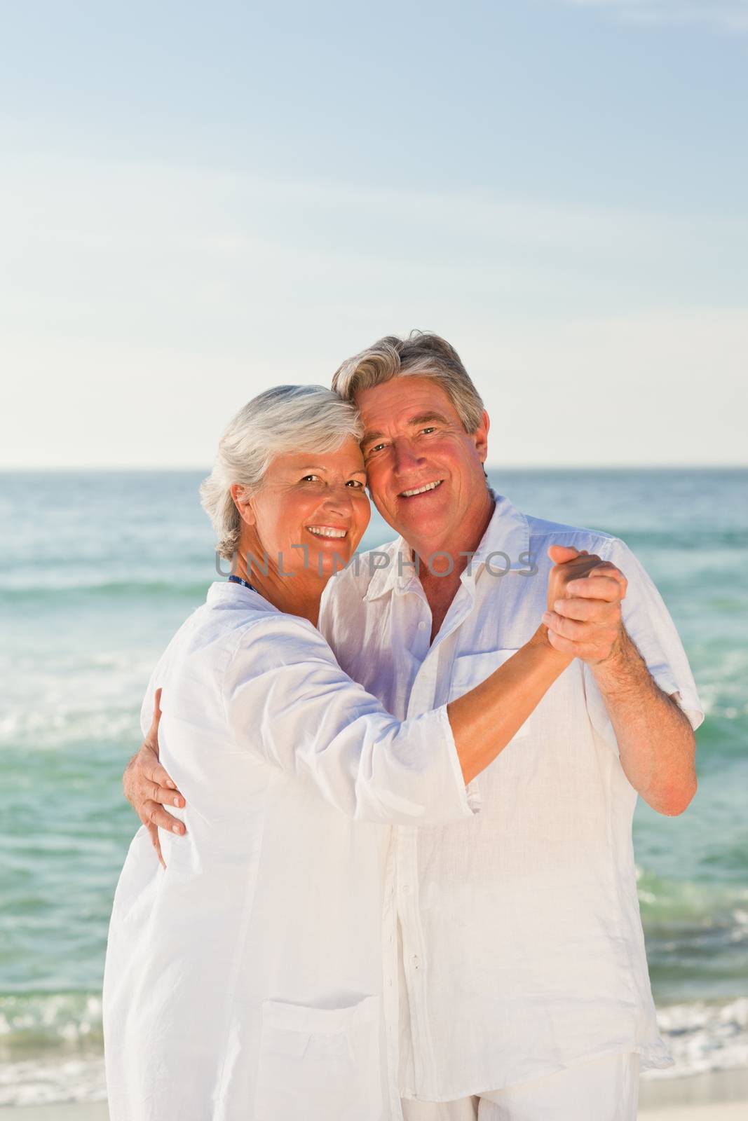 Retired couple dancing on the beach by Wavebreakmedia