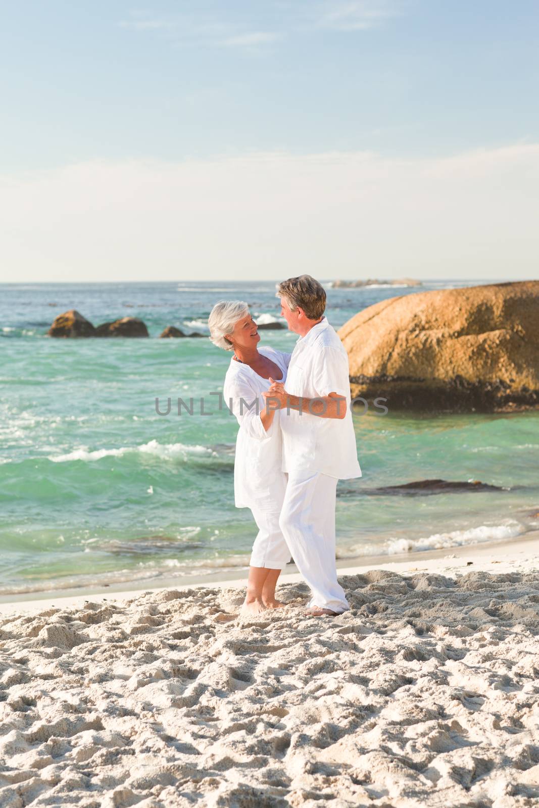 Retired couple dancing on the beach by Wavebreakmedia