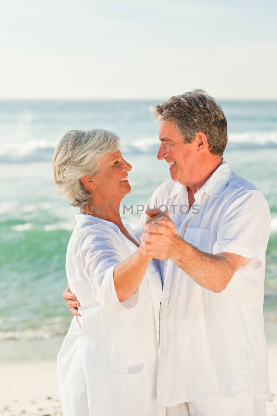 Mature couple dancing on the beach by Wavebreakmedia