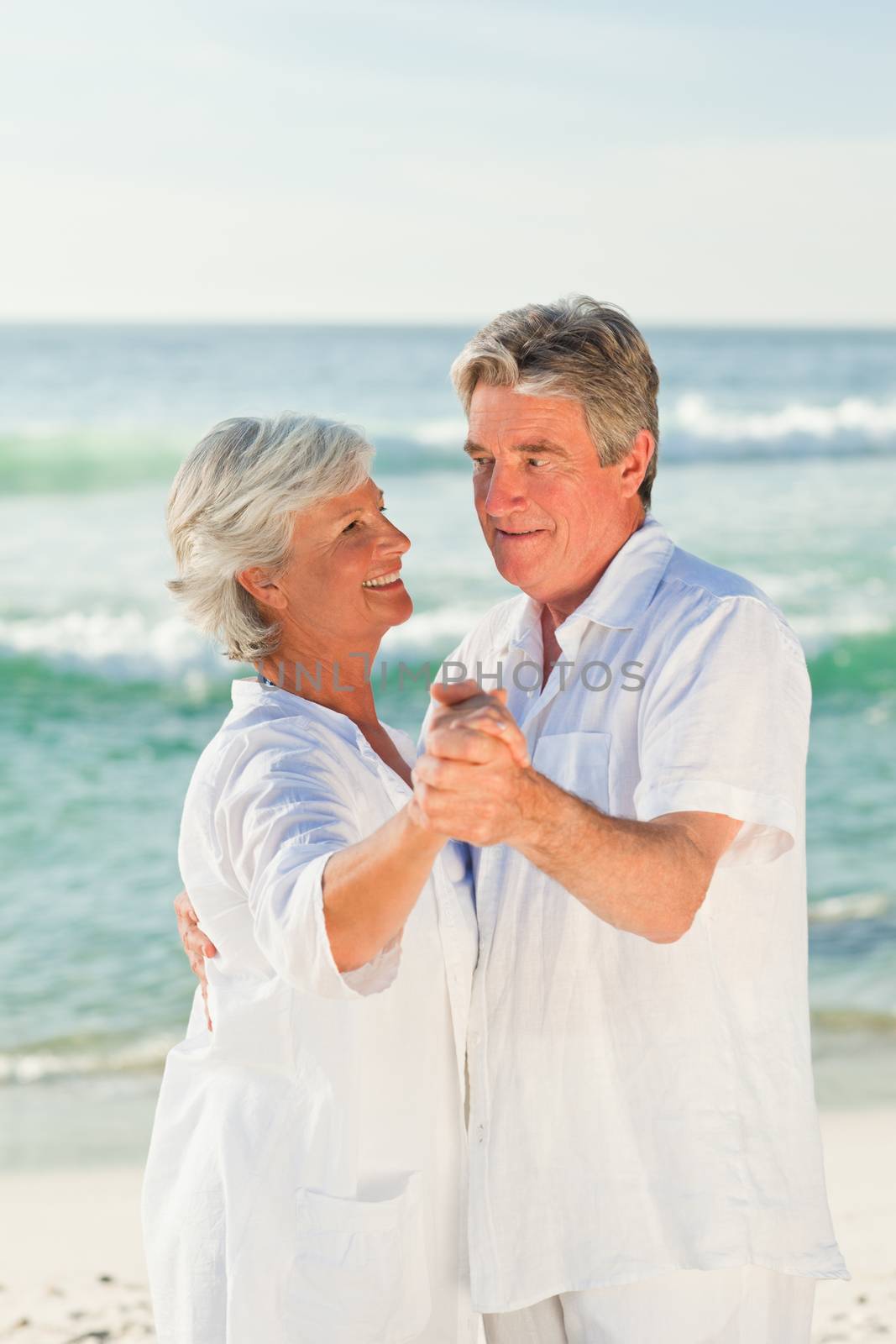 Mature couple dancing on the beach