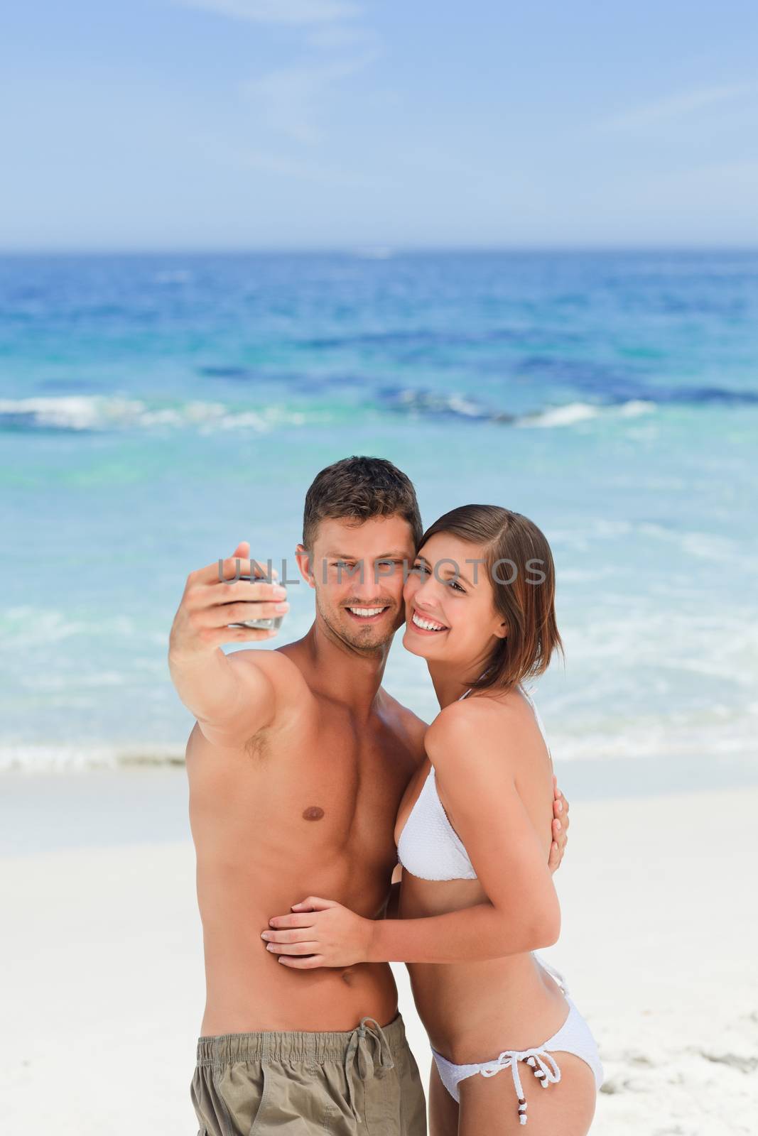 Lovers with their camera at the beach by Wavebreakmedia