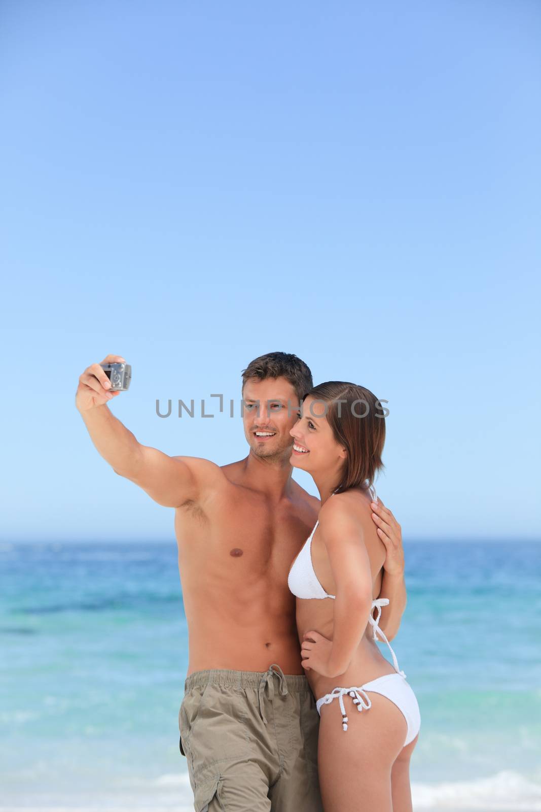 Lovers with their camera at the beach by Wavebreakmedia
