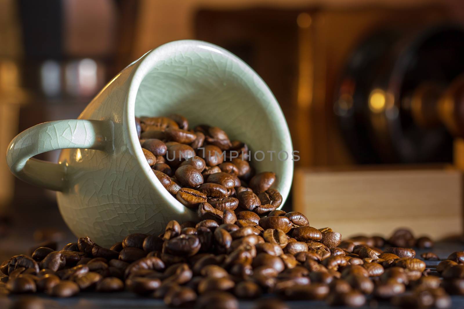 Coffee bean in the white cup and coffee grinder on wooden table. Concept breakfast or coffee time in morning.