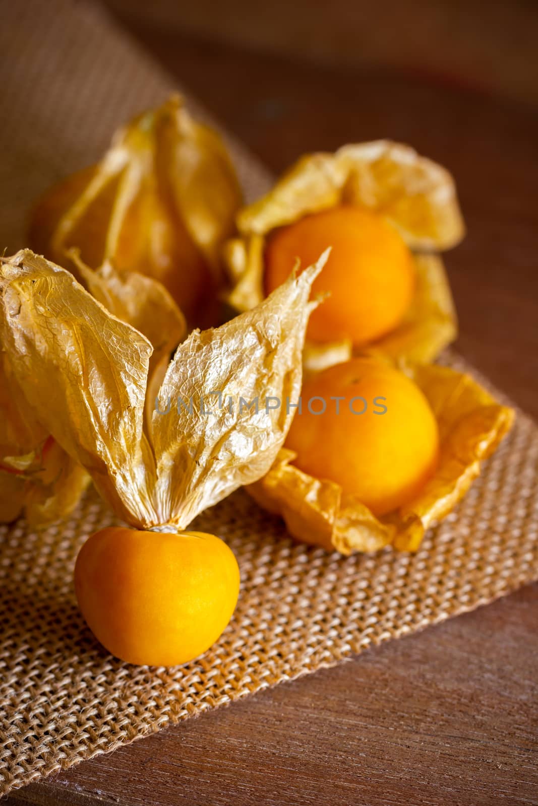 Closeup cape gooseberry on wooden table. Concept of health care or herb.