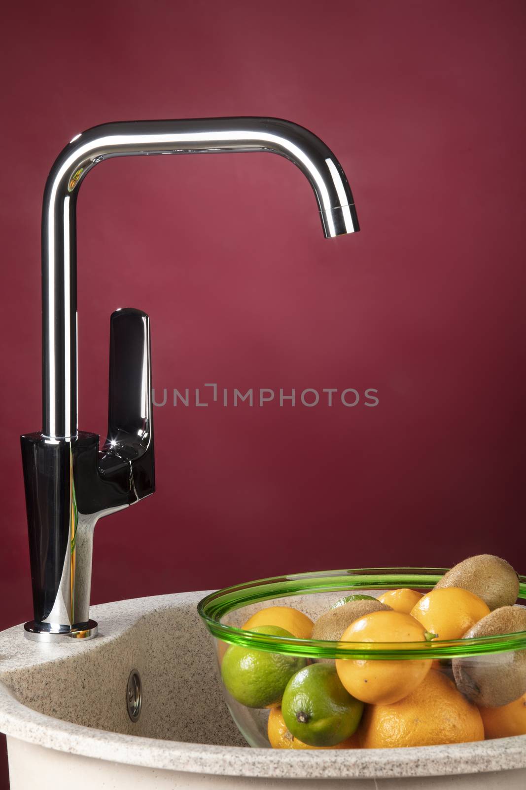 Water mixer and bowl with fruits on a studio background